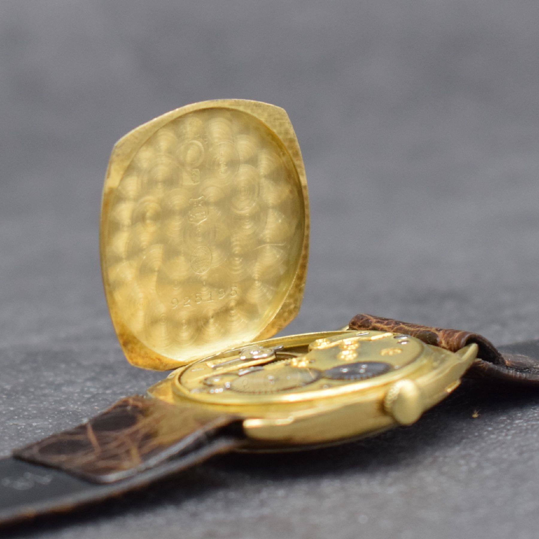 Detail e: IWC frühe Armbanduhr in GG 750/000, Schweiz um 1928, Handaufzug, Carré-Cambré Scharniergeh., Lünette aufgedr., matt gold. Zifferbl., arab. ...