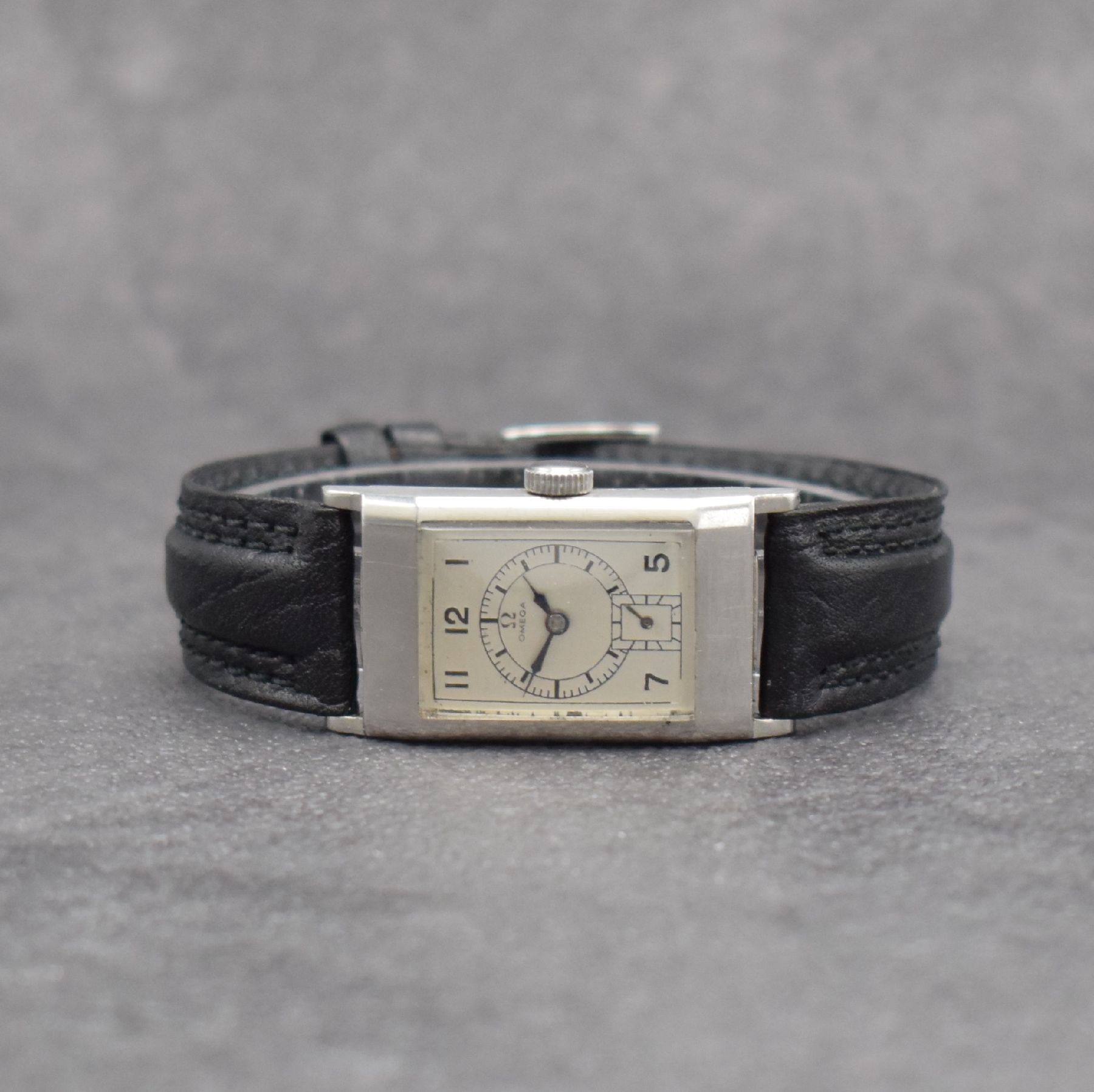 OMEGA rechteckige Armbanduhr Kaliber T17, Schweiz um 1937, Handaufzug, leicht gewölbtes Edelstahlgehäuse, Boden aufgedr., silb. Zifferbl. ...