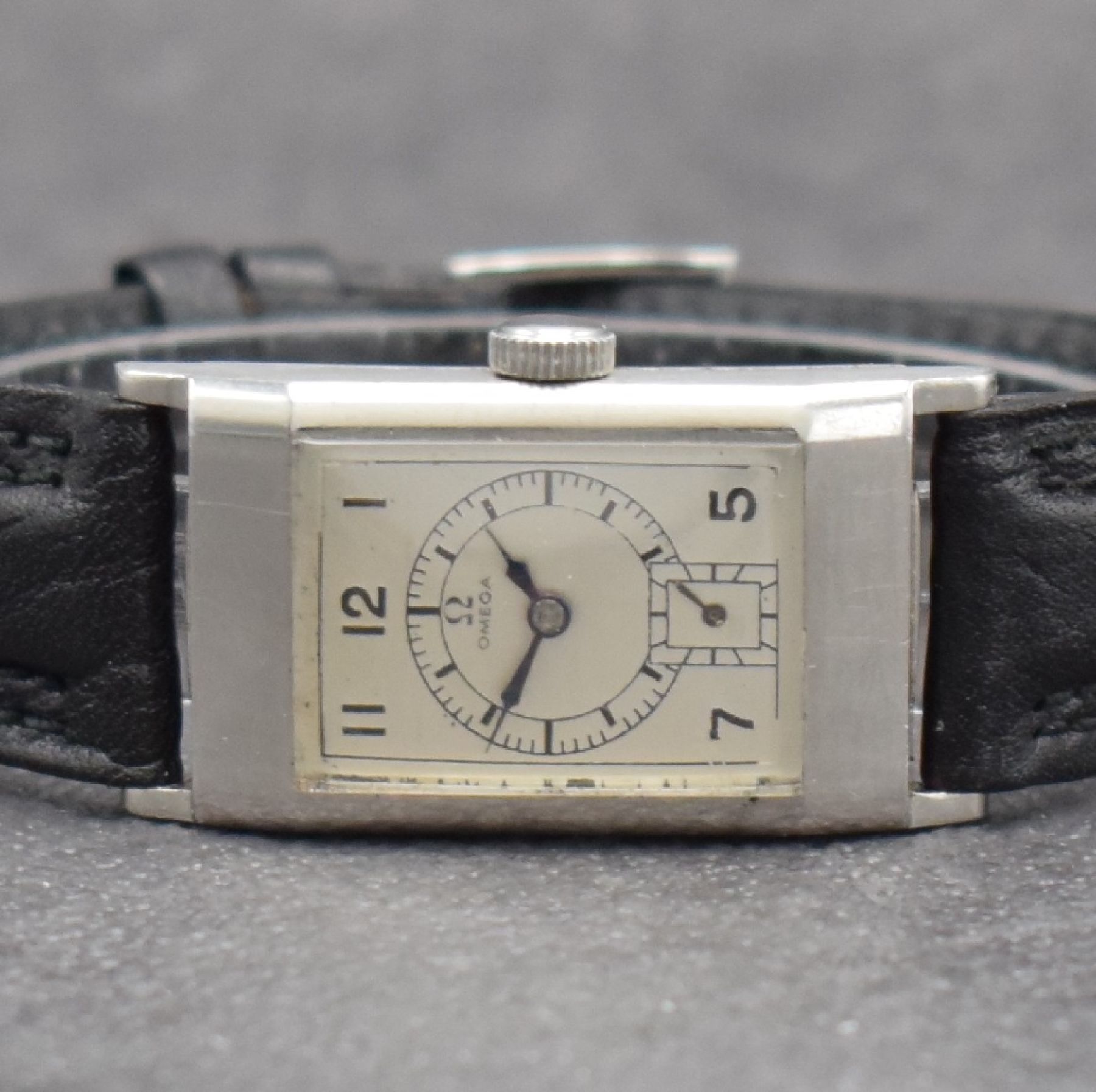 Detail a: OMEGA rechteckige Armbanduhr Kaliber T17, Schweiz um 1937, Handaufzug, leicht gewölbtes Edelstahlgehäuse, Boden aufgedr., silb. Zifferbl. ...