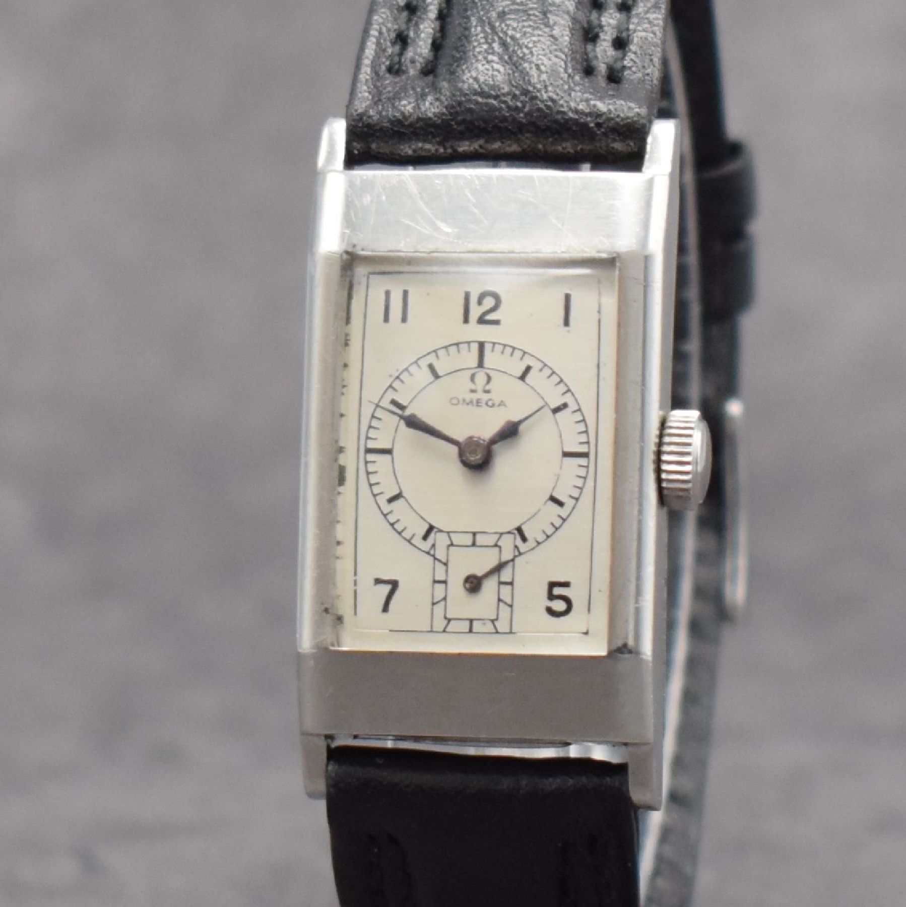 Detail c: OMEGA rechteckige Armbanduhr Kaliber T17, Schweiz um 1937, Handaufzug, leicht gewölbtes Edelstahlgehäuse, Boden aufgedr., silb. Zifferbl. ...