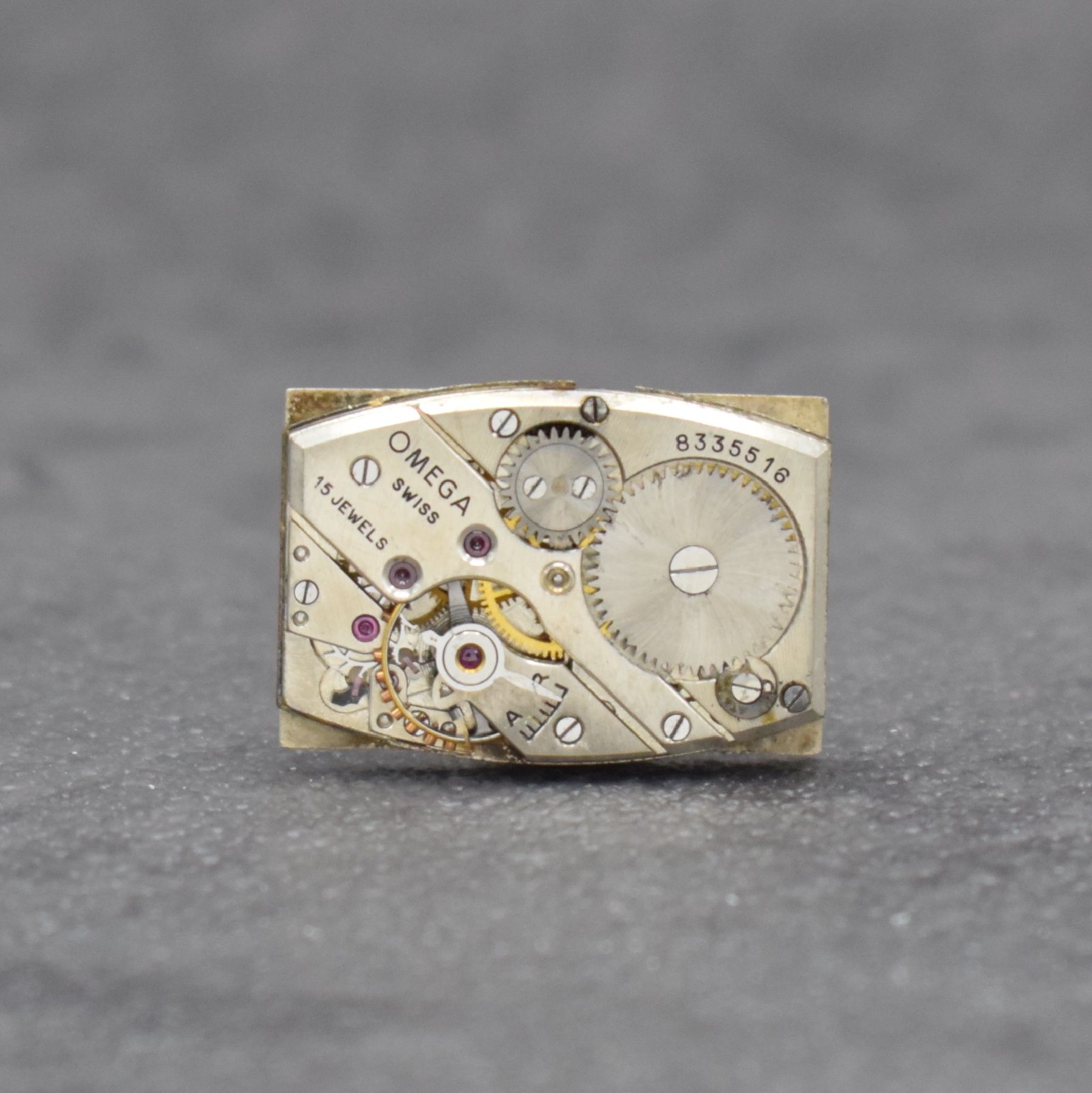Detail e: OMEGA rechteckige Armbanduhr Kaliber T17, Schweiz um 1937, Handaufzug, leicht gewölbtes Edelstahlgehäuse, Boden aufgedr., silb. Zifferbl. ...