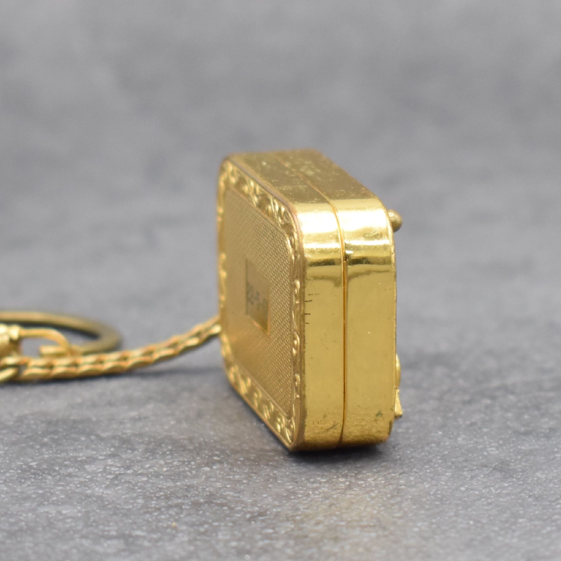Detail a: REUGE Miniatur-Spieluhr an Kette, Schweiz um 1960, klassische Melodie, verg. Gehäuse beids. guill. & floral graviert, Boden m. Datumsgravur, ...