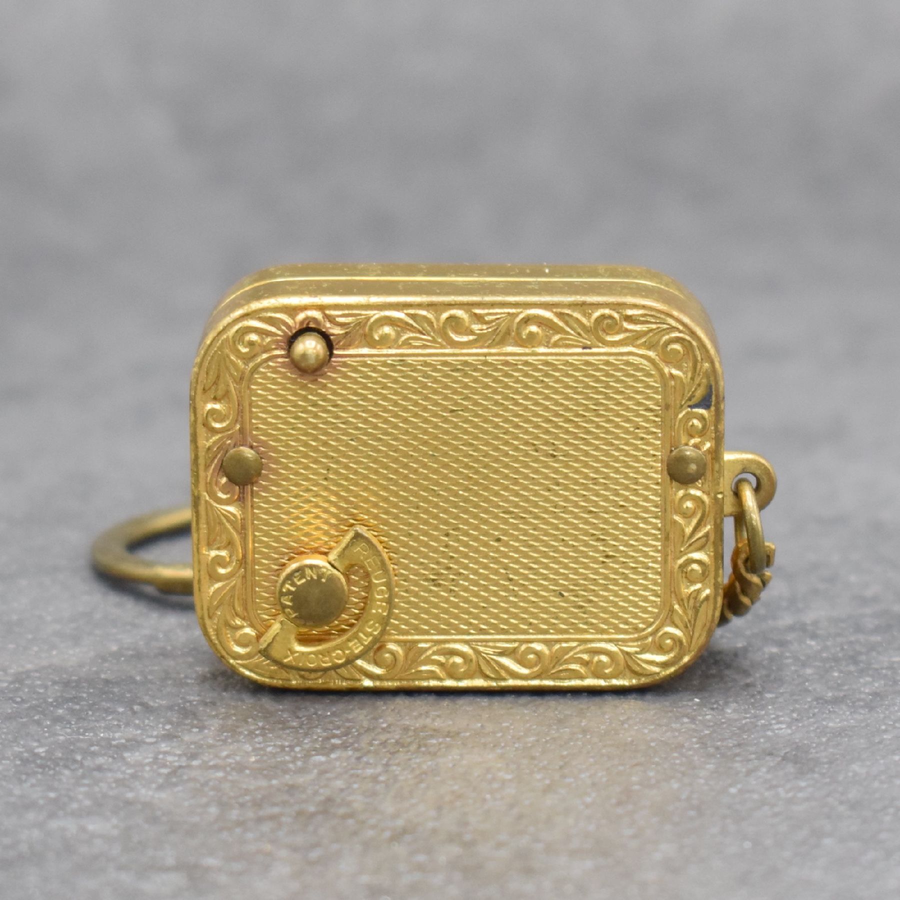 Detail b: REUGE Miniatur-Spieluhr an Kette, Schweiz um 1960, klassische Melodie, verg. Gehäuse beids. guill. & floral graviert, Boden m. Datumsgravur, ...