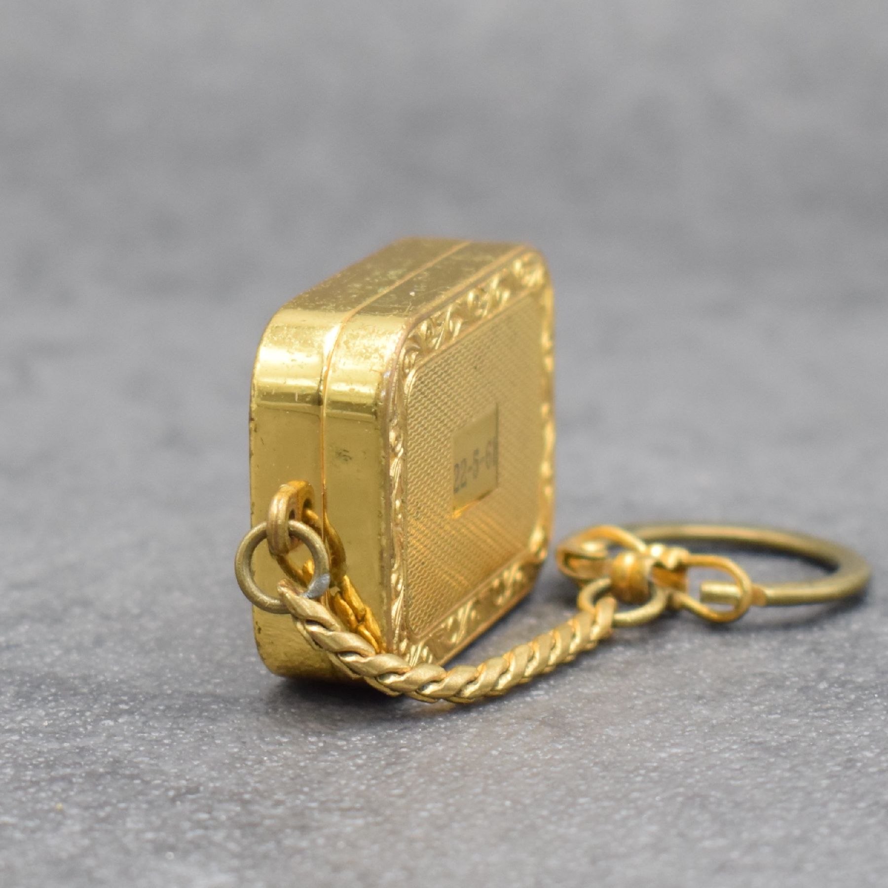 Detail c: REUGE Miniatur-Spieluhr an Kette, Schweiz um 1960, klassische Melodie, verg. Gehäuse beids. guill. & floral graviert, Boden m. Datumsgravur, ...