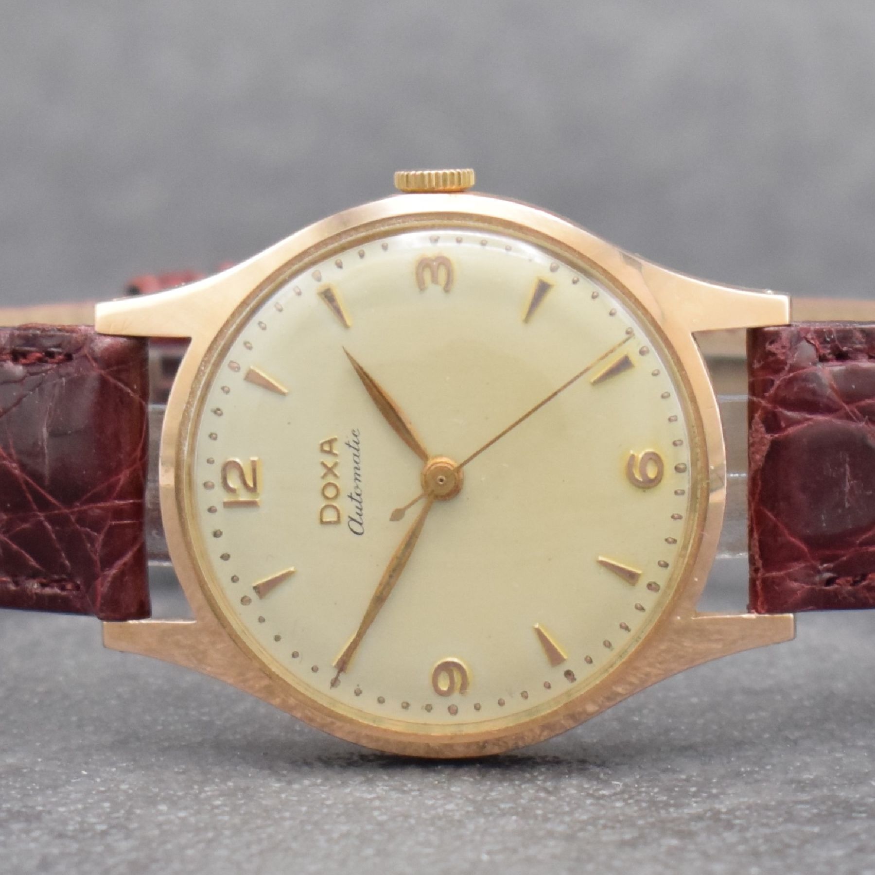 Detail a: DOXA Herrenarmbanduhr in RG 585/000, Schweiz um 1955, Automatik, 2-tlg. Geh., Boden aufgedr., silb. Zifferbl., rotgold. Indizes & Zeiger, ...