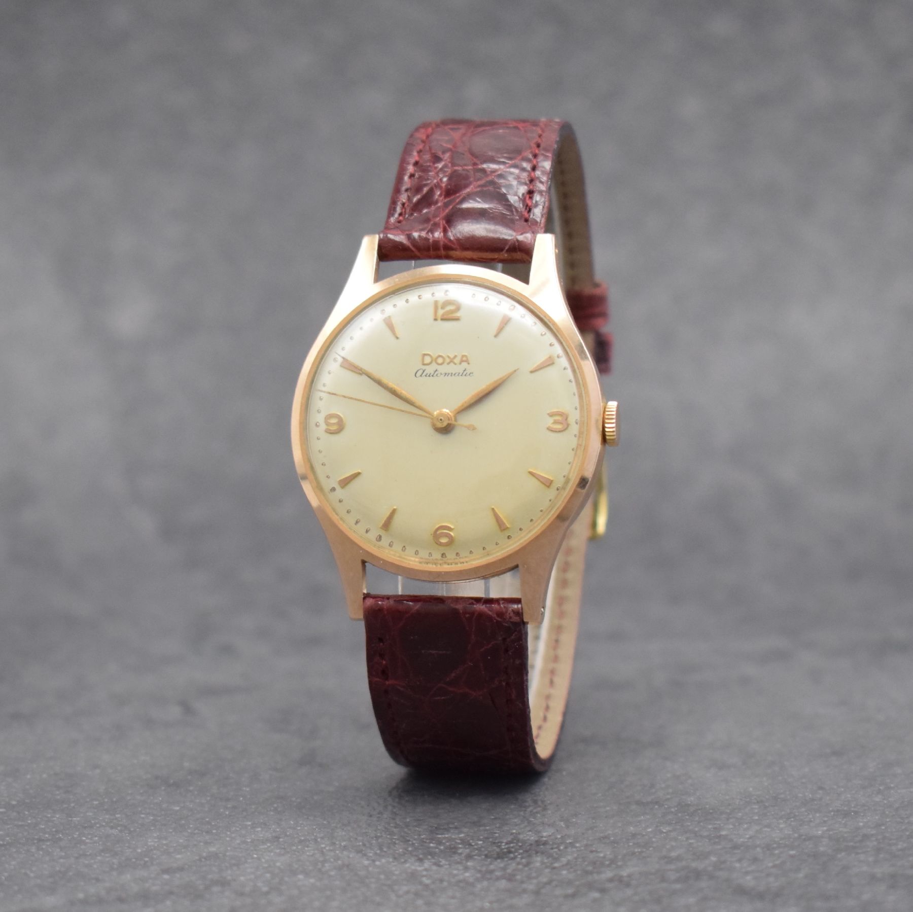 Detail b: DOXA Herrenarmbanduhr in RG 585/000, Schweiz um 1955, Automatik, 2-tlg. Geh., Boden aufgedr., silb. Zifferbl., rotgold. Indizes & Zeiger, ...