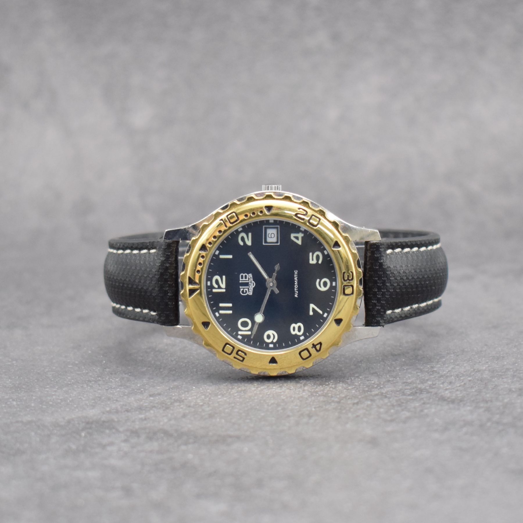GUB Herrenarmbanduhr, Schweiz/Deutschland um 1992, Automatik, gedr. Stahlgeh., Lünette m. 60er Teilung eins. rast. drehb., schwarzes Zifferbl. m. ...