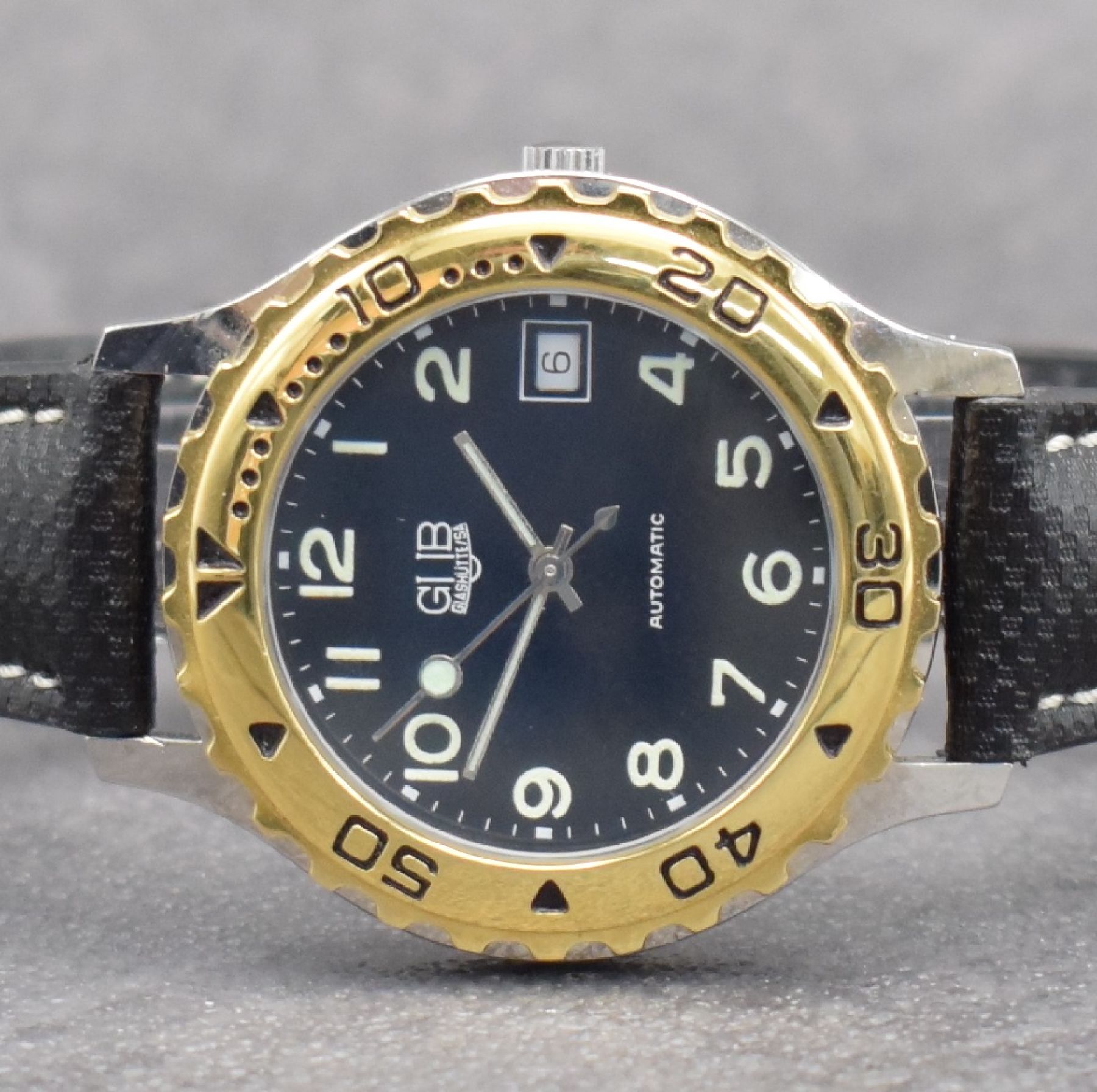 Detail a: GUB Herrenarmbanduhr, Schweiz/Deutschland um 1992, Automatik, gedr. Stahlgeh., Lünette m. 60er Teilung eins. rast. drehb., schwarzes Zifferbl. m. ...