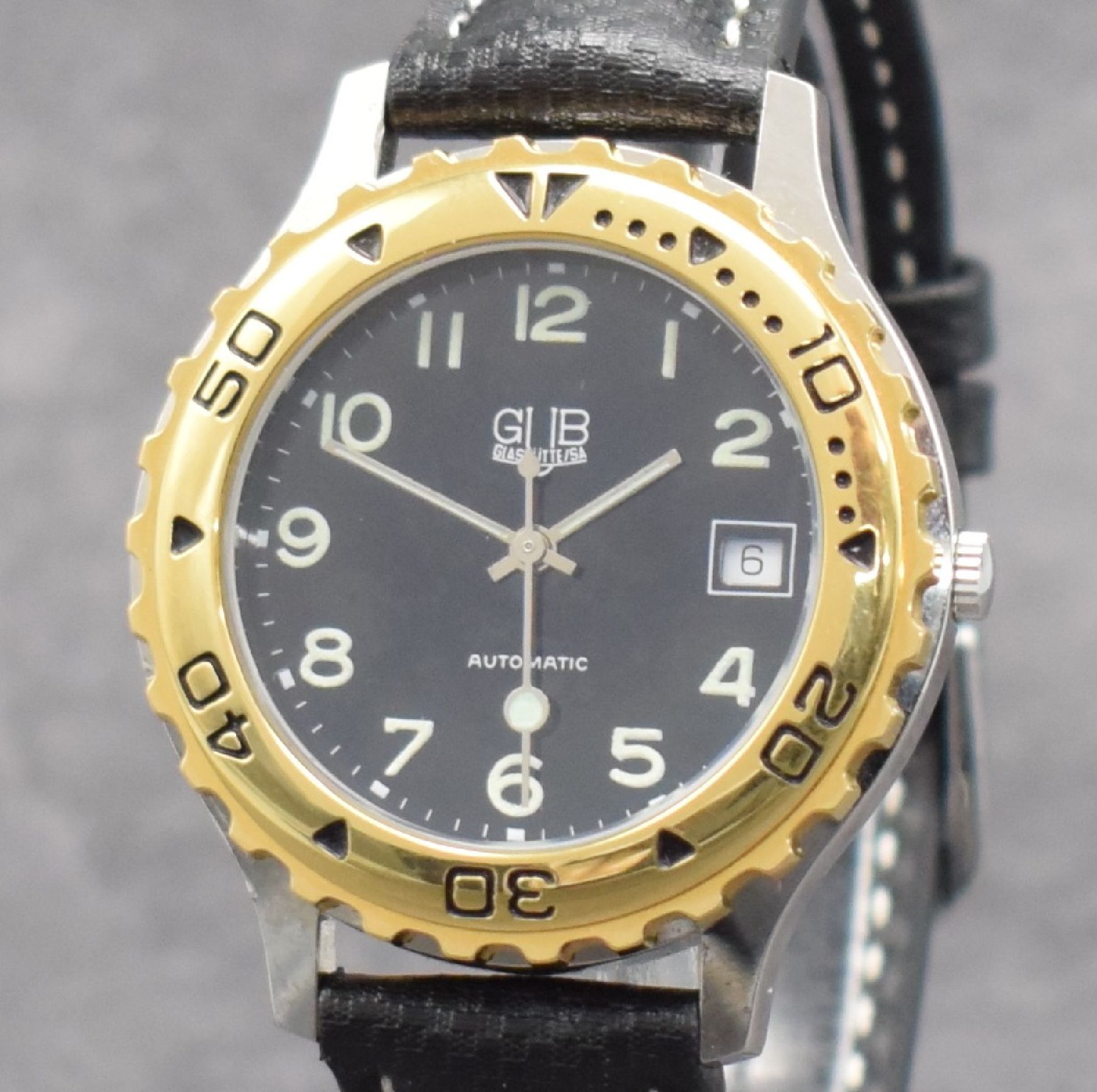 Detail c: GUB Herrenarmbanduhr, Schweiz/Deutschland um 1992, Automatik, gedr. Stahlgeh., Lünette m. 60er Teilung eins. rast. drehb., schwarzes Zifferbl. m. ...