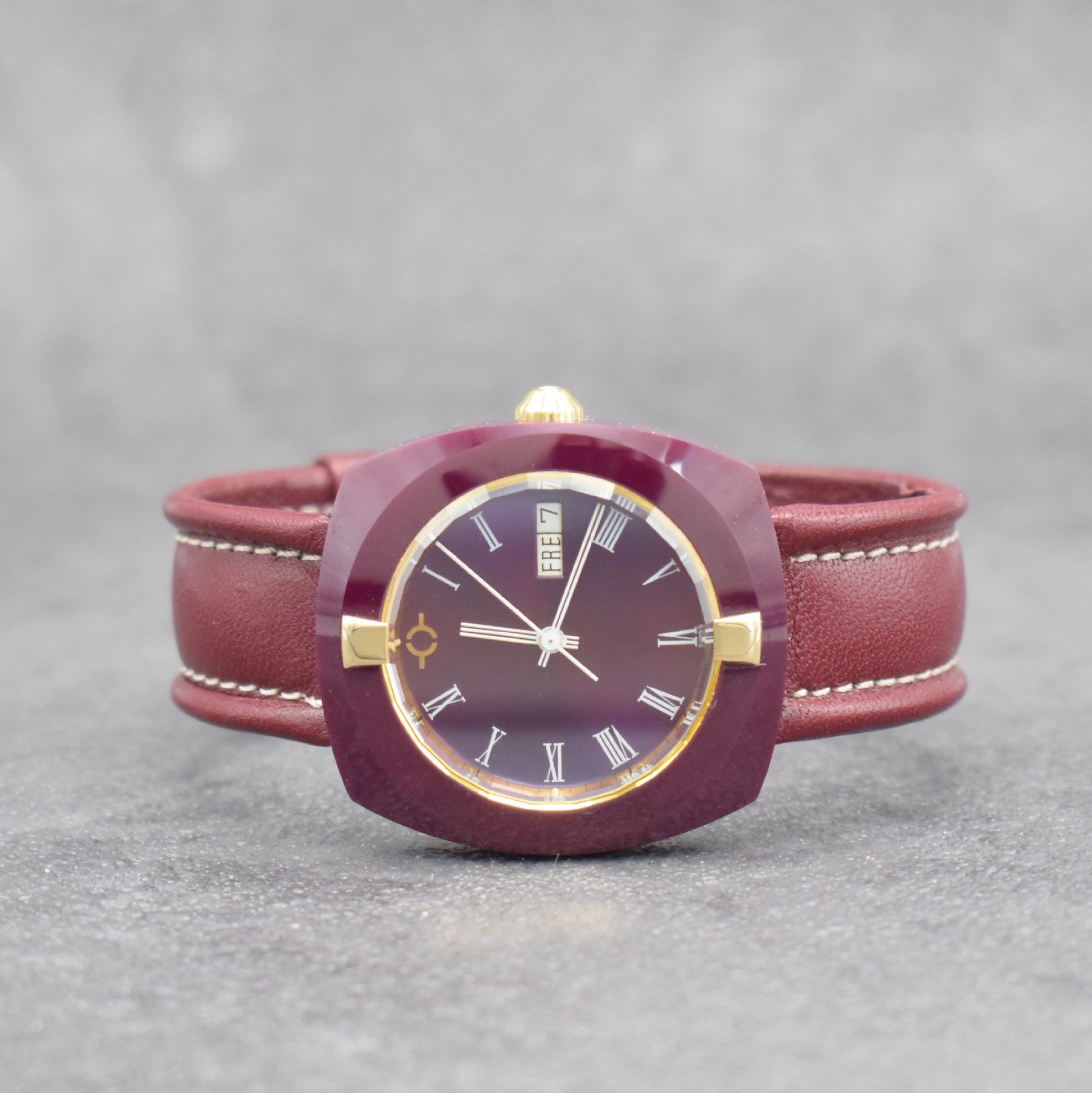 VACUUM Armbanduhr im Rubin-Gehäuse, Schweiz um 1980, quarz, Monocoque-Geh., facettiertes Saphirglas m. 2 gold. Haltern rücks. verschr., Rubin-rotes ...