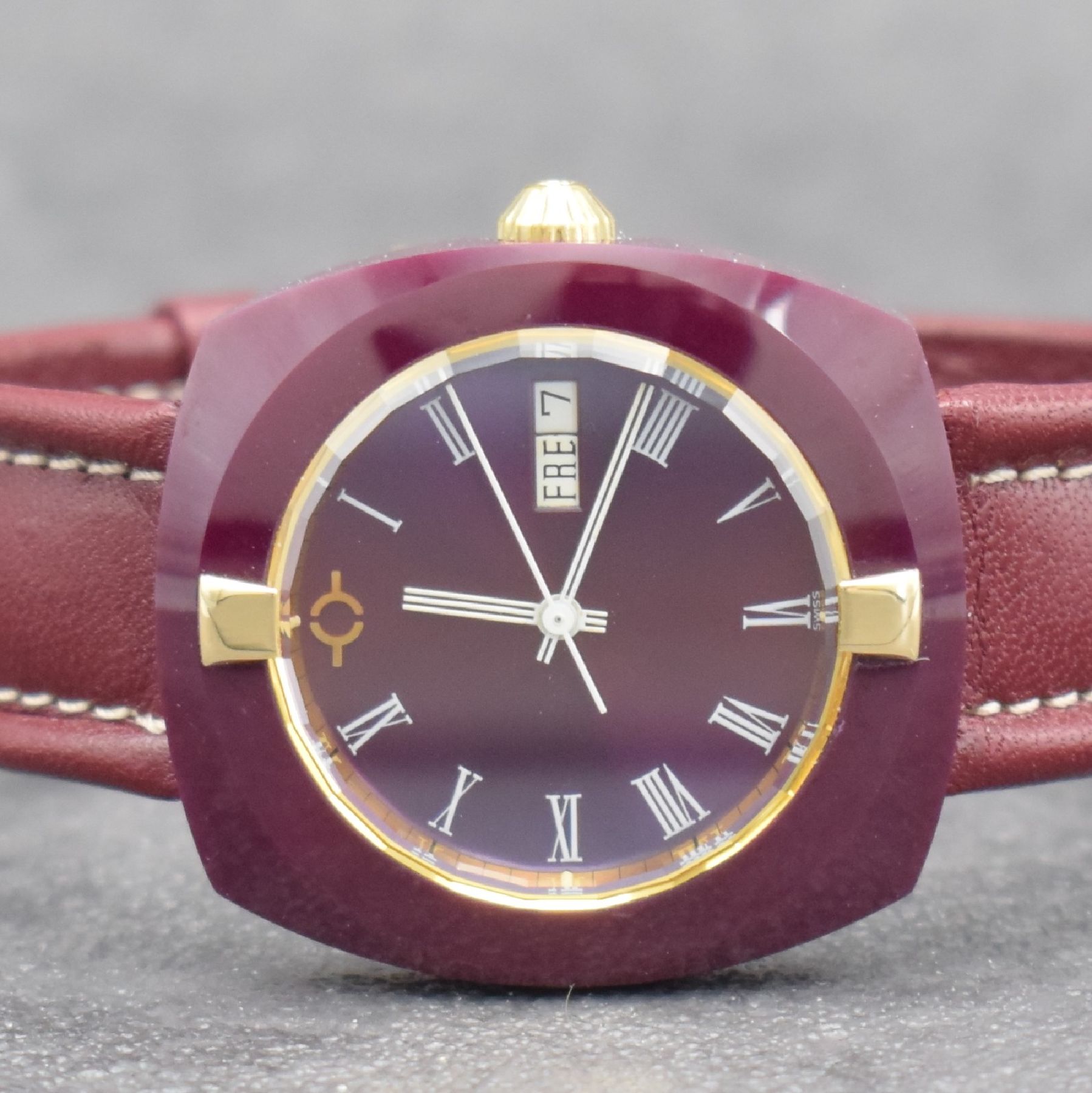 Detail a: VACUUM Armbanduhr im Rubin-Gehäuse, Schweiz um 1980, quarz, Monocoque-Geh., facettiertes Saphirglas m. 2 gold. Haltern rücks. verschr., Rubin-rotes ...