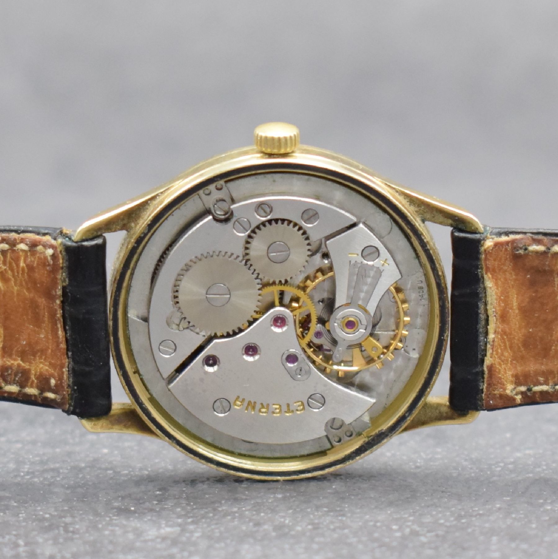 Detail e: ETERNA Herrenarmbanduhr in GG 585/000, Handaufzug, Schweiz Ende 1950er Jahre, Boden m. Widmungsgravur verschr., silb. Zifferbl. m. aufgel. Indizes l. ...