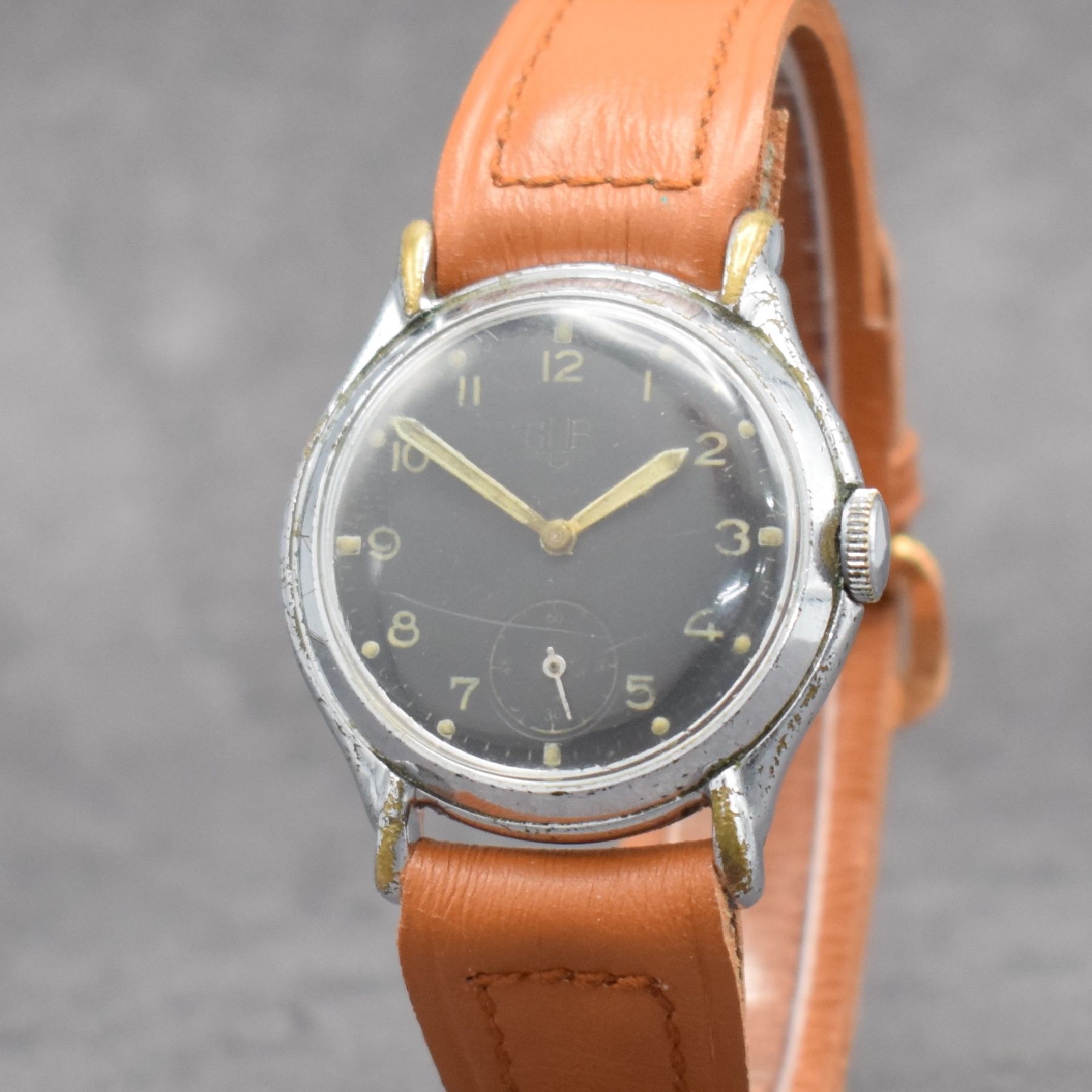 Detail a: GUB Herrenarmbanduhr mit Kaliber 60, Handaufzug, DDR um 1952, verchr. Metallgeh. m. ausgef. Bandanst. ber., Edelstahlboden aufgedr., schwarzes ...