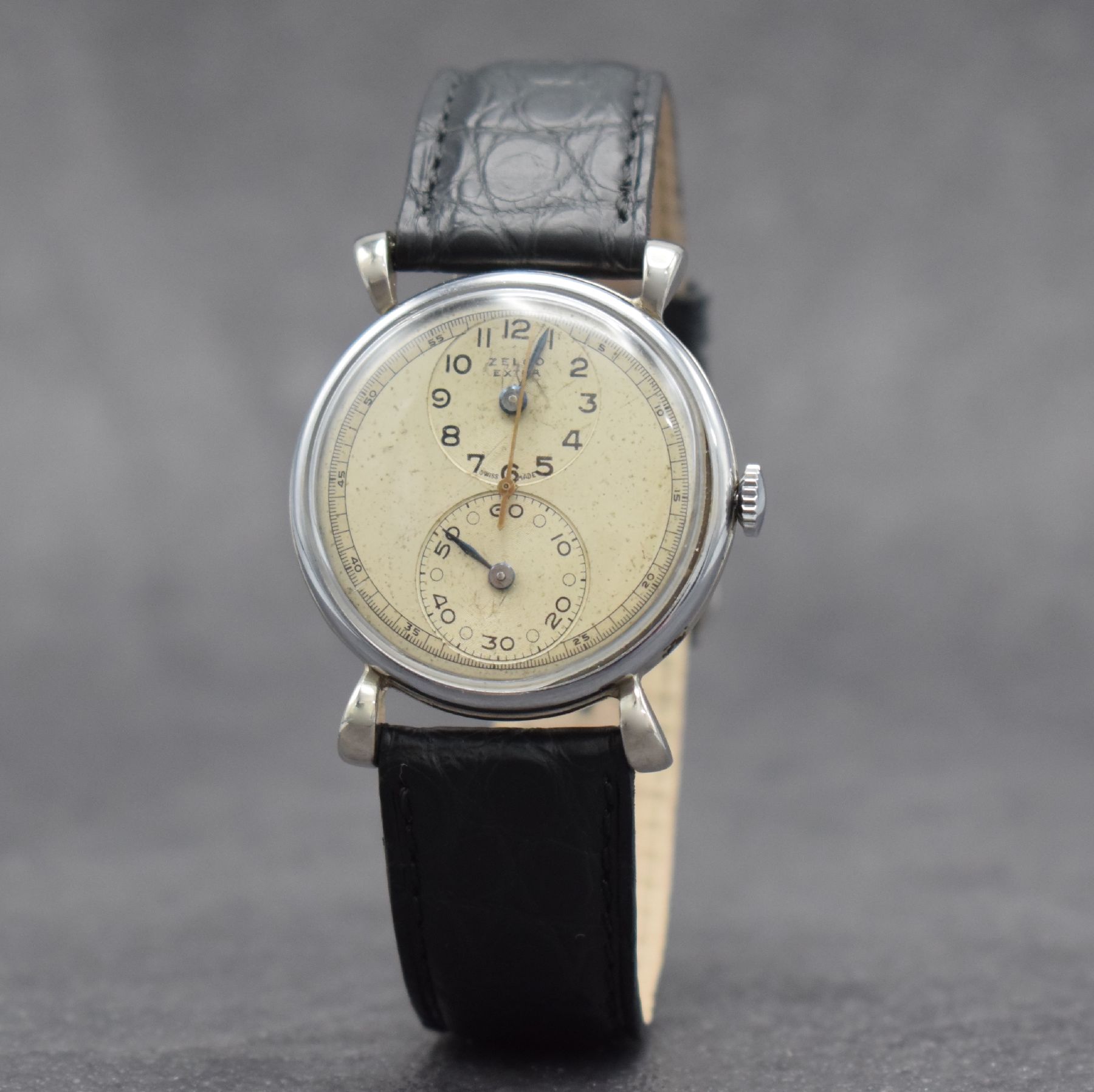 Detail b: ZELCO EXTRA Regulateur Herrenarmbanduhr, Schweiz um 1940, Handaufzug, verchr. Geh., Edelstahlboden & Glasrand aufgedr., silb. Duoton-Zifferbl. ...