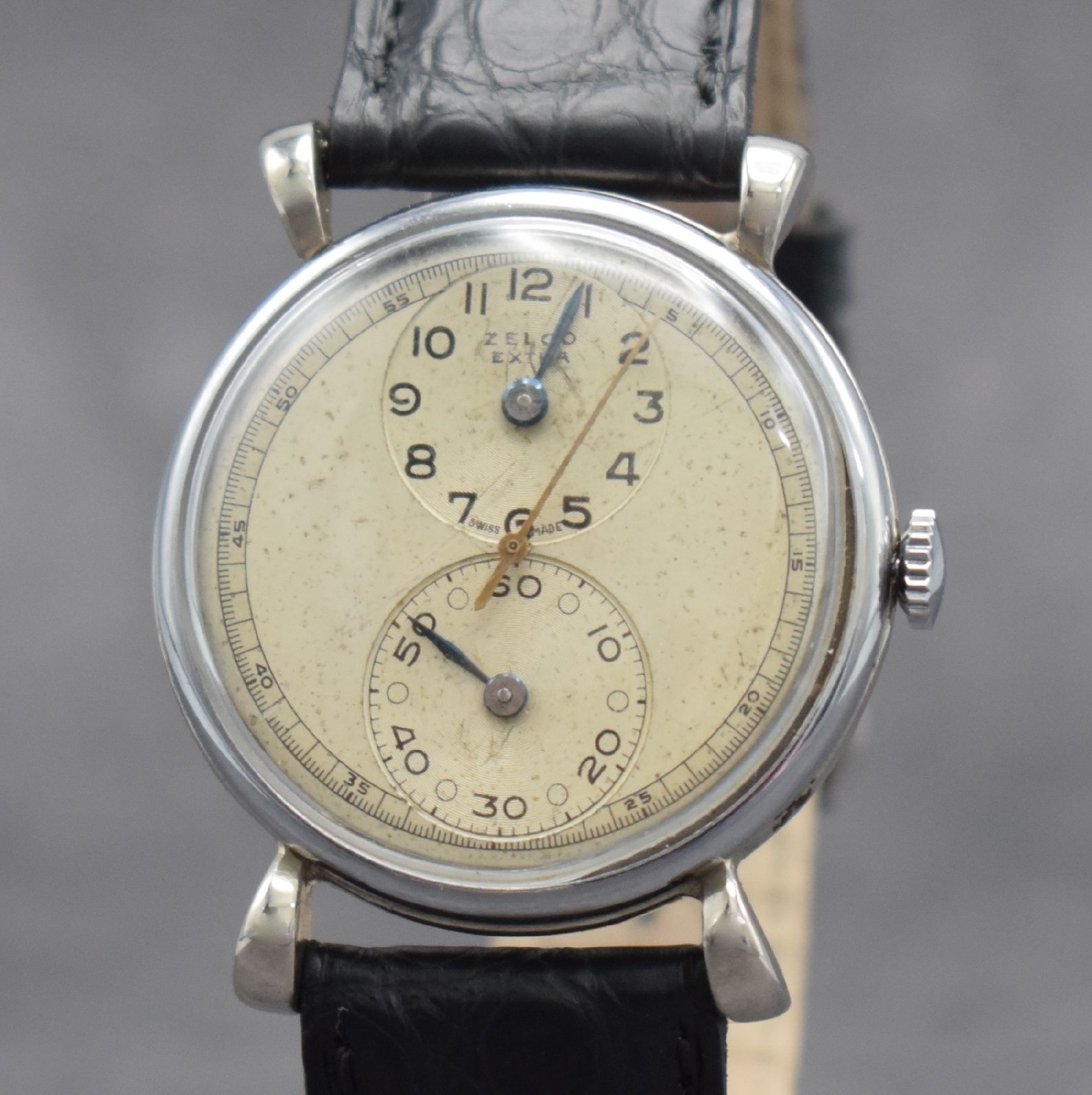 Detail c: ZELCO EXTRA Regulateur Herrenarmbanduhr, Schweiz um 1940, Handaufzug, verchr. Geh., Edelstahlboden & Glasrand aufgedr., silb. Duoton-Zifferbl. ...