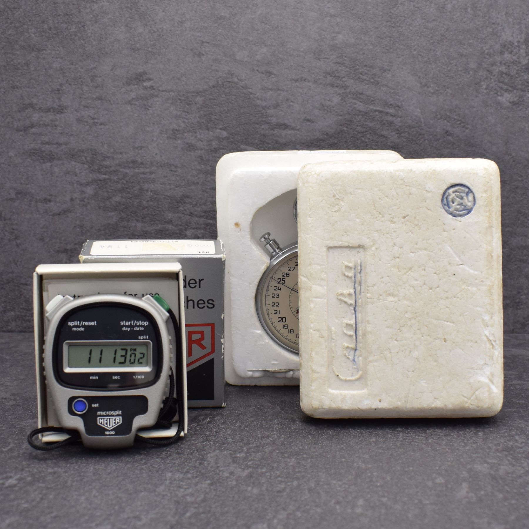 Detail h: Konvolut: 2 Stoppuhren, 1) HEUER microsplit Einhandstoppuhr, Schweiz um 1975, mit digitaler Anzeige, orig. Etui & Gebrauchsanweisung anbei, EZ 2 2) ...