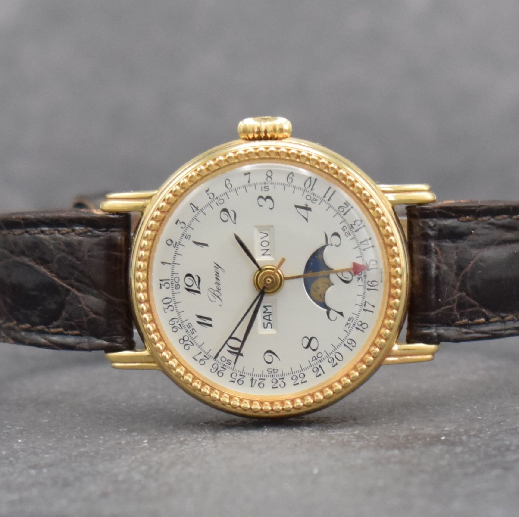Detail a: BERNEY Damenarmbanduhr mit Vollkalender in GG 750/000, Schweiz um 1980, Handaufzug, 3- teil. Geh., Boden & Glasrand aufgedr., silb. Zifferbl. m. ...