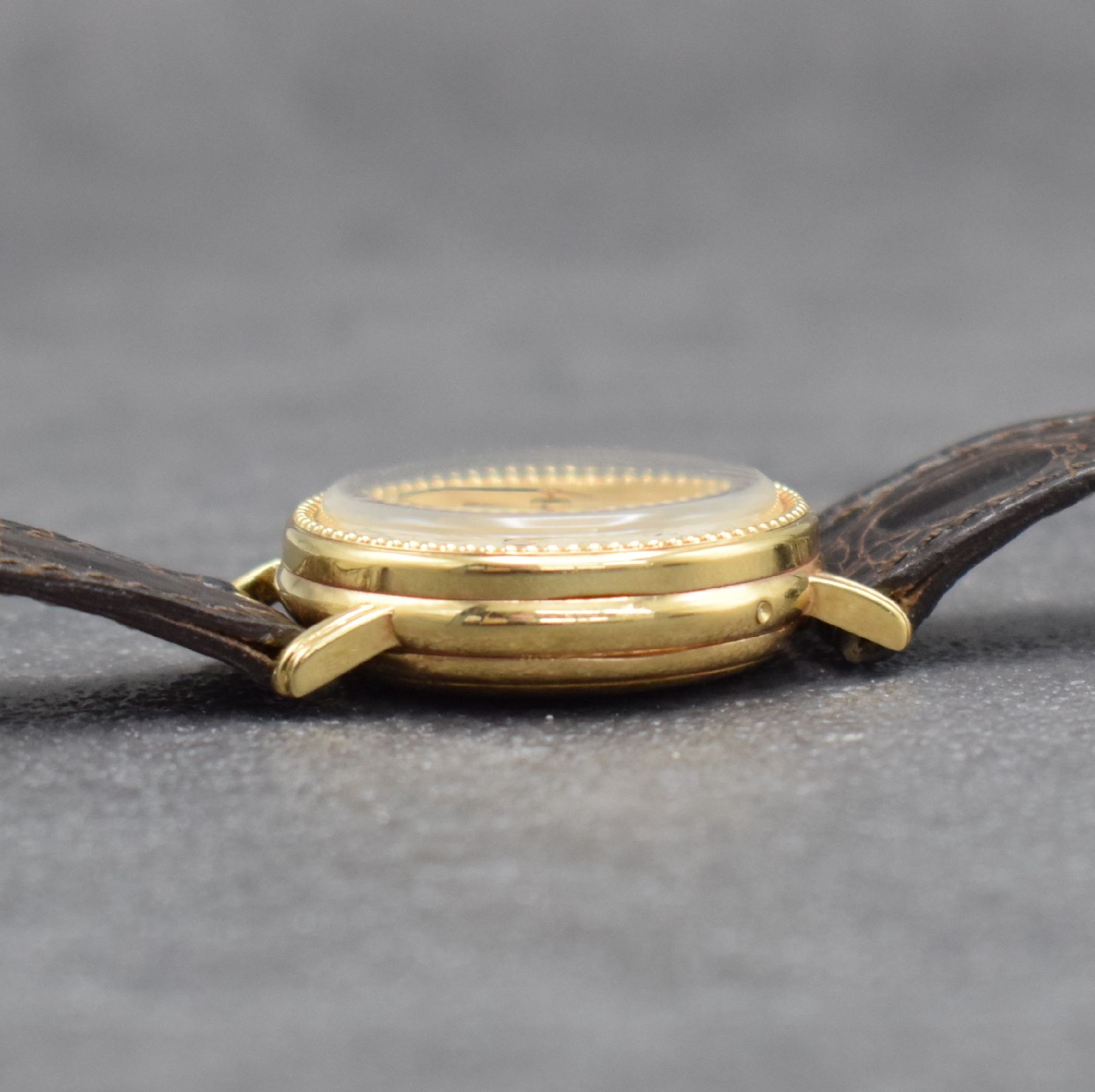 Detail e: BERNEY Damenarmbanduhr mit Vollkalender in GG 750/000, Schweiz um 1980, Handaufzug, 3- teil. Geh., Boden & Glasrand aufgedr., silb. Zifferbl. m. ...