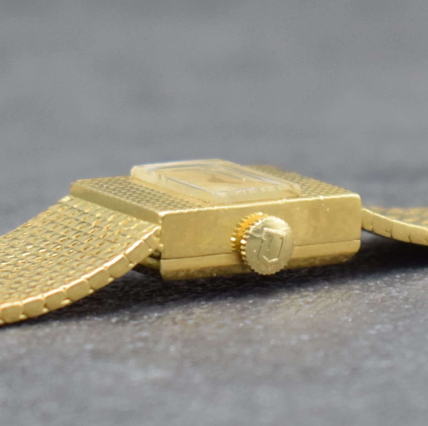 Detail e: UNIVERSAL GENEVE Damenarmbanduhr in GG 750/000, Schweiz um 1965, Handaufzug, rechteck. Geh. m. anges. Pyramiden- Milanaiseband, Boden aufgedr., gold. ...