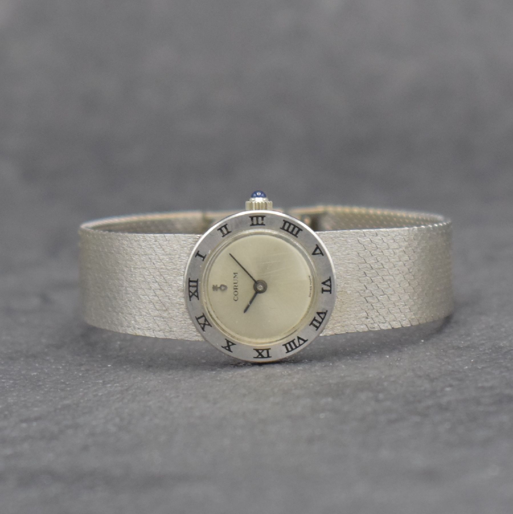 CORUM feine Damengoldbanduhr in WG 750/000, Schweiz um 1965, Handaufzug, gedr. Geh., Lünette m. röm. Std.-Zahlen, fixiertes Milanaiseband, silb. ...