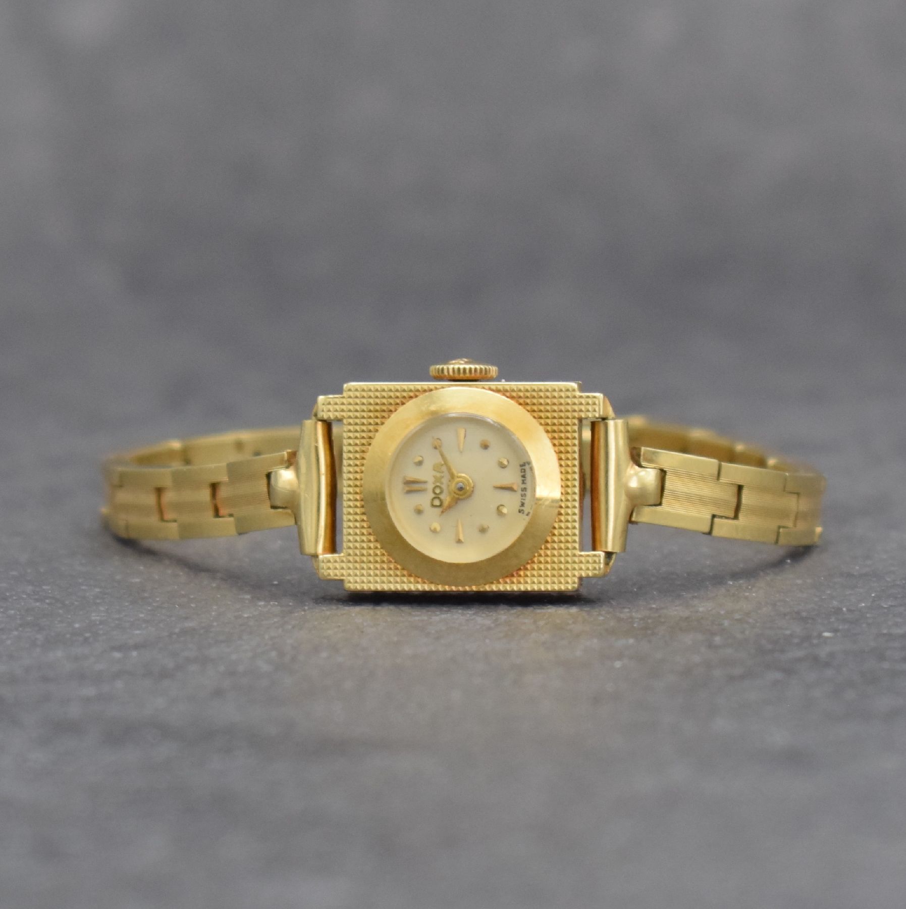 DOXA Damengoldbanduhr in GG 585/000, Schweiz um 1960, Handaufzug, rechteck. Geh. m. guill.Front, Boden aufgedr., Gliederband von Kiefer, silb. ...