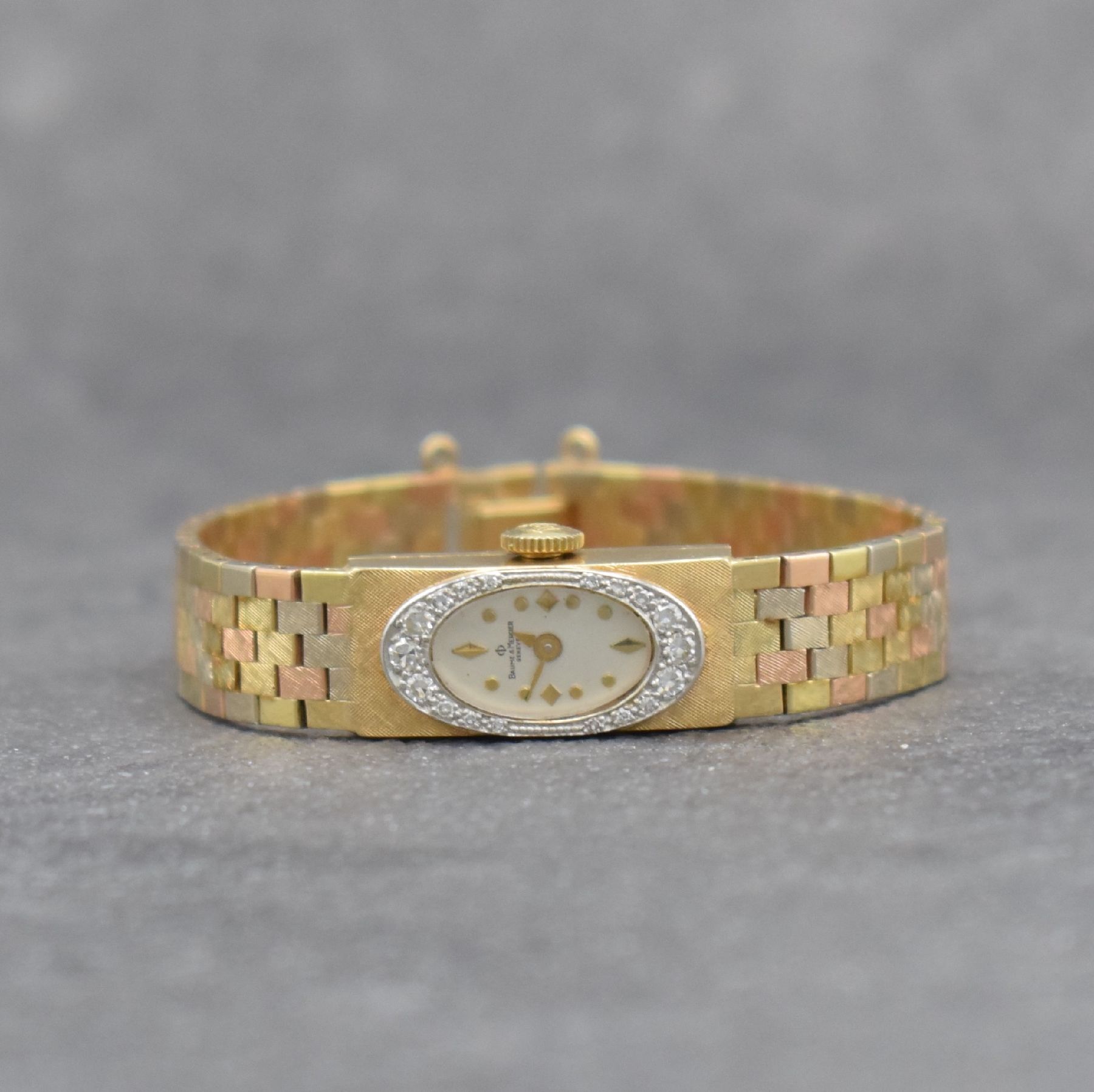 BAUME & MERCIER Diamantbesetzte 3-farbige Damenarmbanduhr in GG/RG/WG 585/000, Schweiz um 1960, Handaufzug, Baguette-Geh. m. schraffierter Front, ...