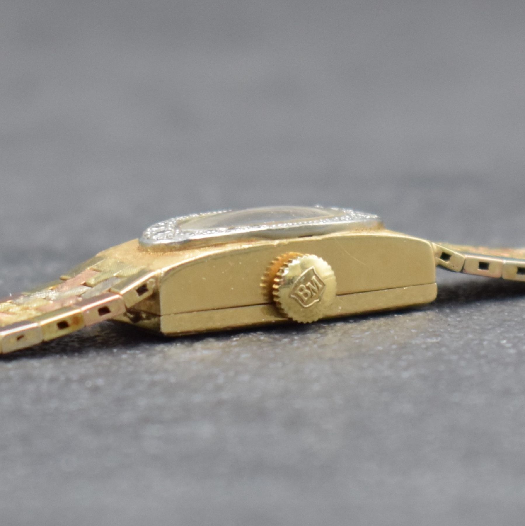 Detail e: BAUME & MERCIER Diamantbesetzte 3-farbige Damenarmbanduhr in GG/RG/WG 585/000, Schweiz um 1960, Handaufzug, Baguette-Geh. m. schraffierter Front, ...