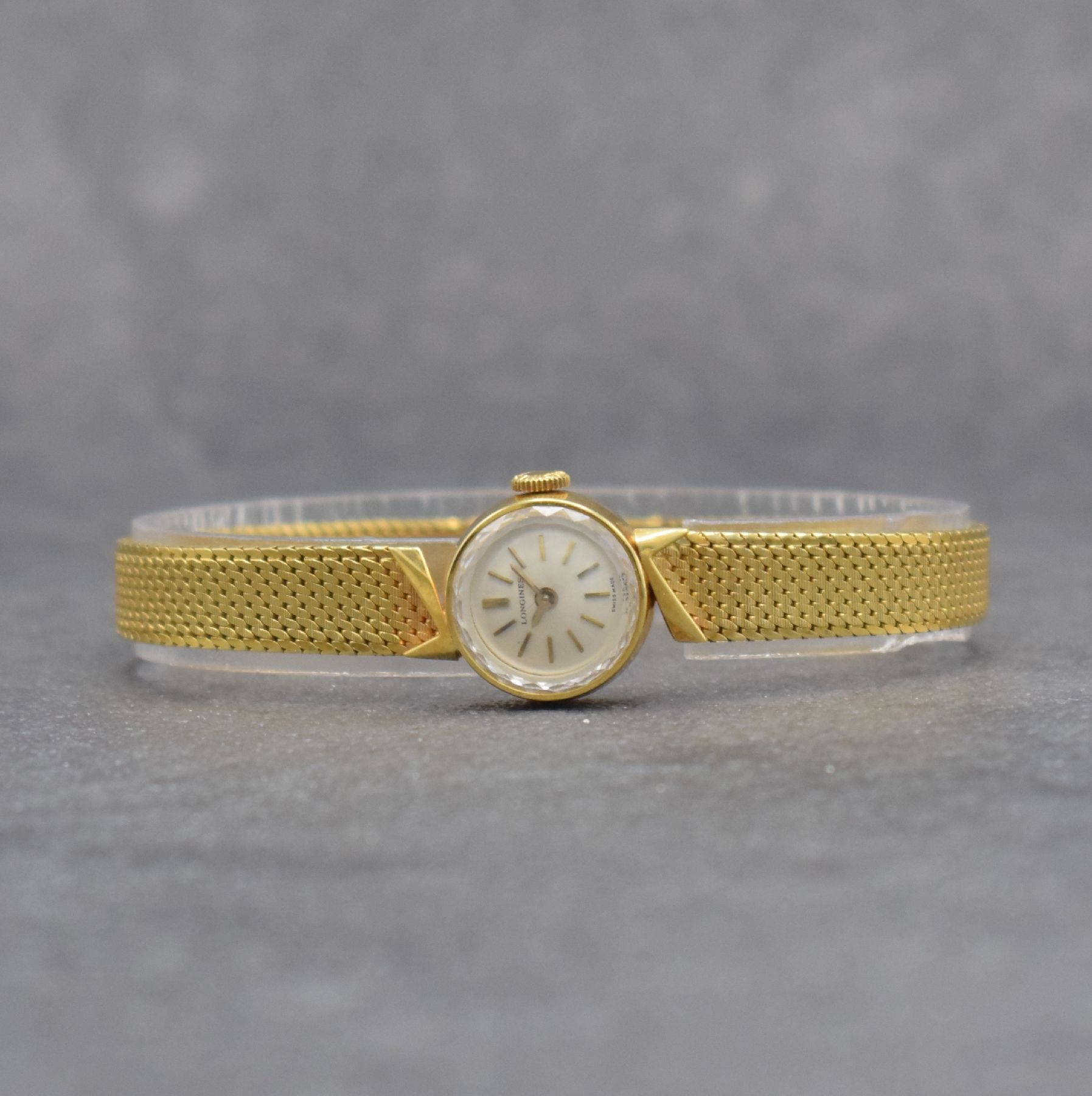 LONGINES Damengoldbanduhr in GG 750/000, Schweiz um 1965, Handaufzug, gedr. Geh., anges. Milanaiseband, orig. Krone, silb. Zifferbl., gold. Indizes & ...