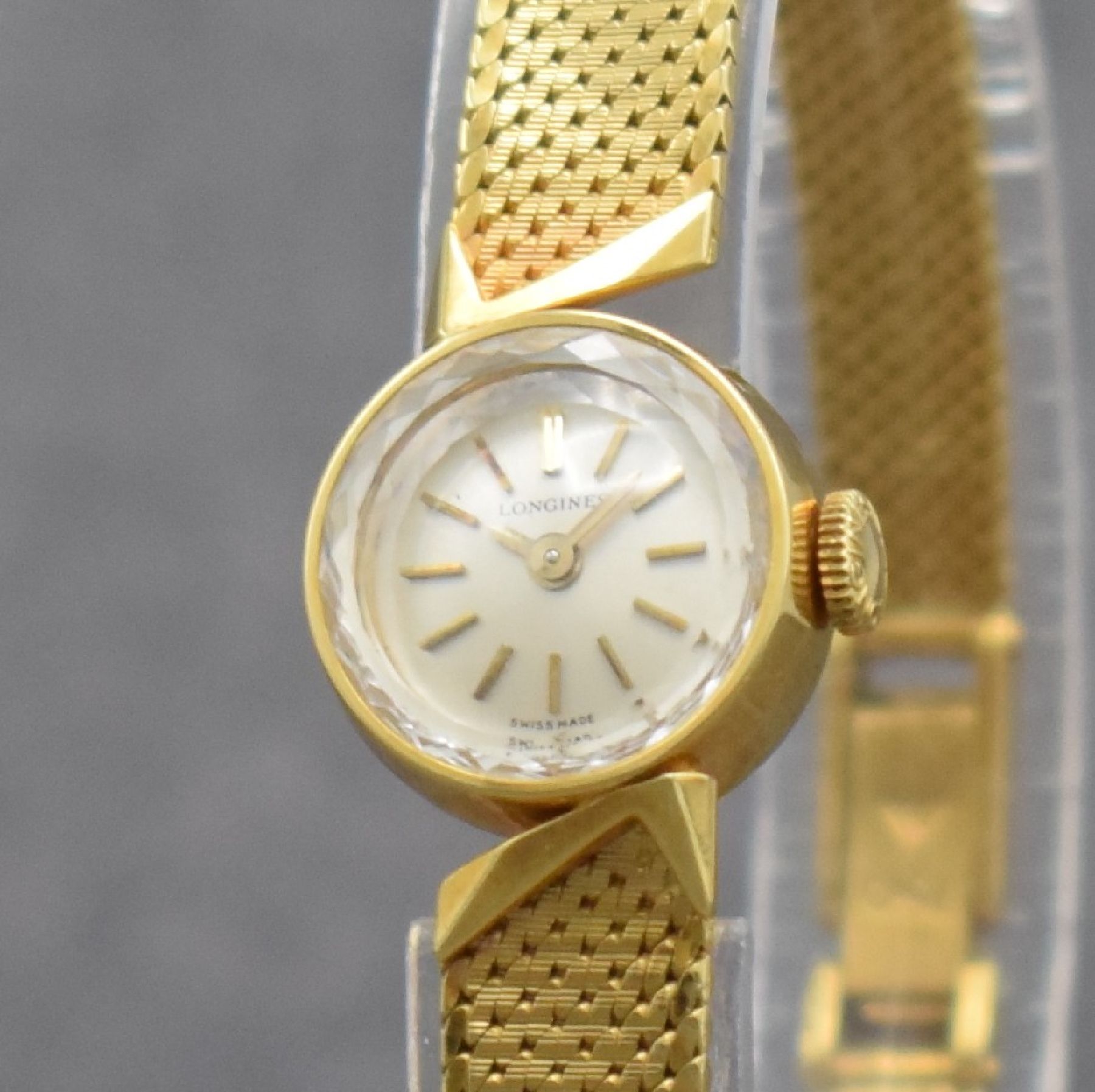 Detail c: LONGINES Damengoldbanduhr in GG 750/000, Schweiz um 1965, Handaufzug, gedr. Geh., anges. Milanaiseband, orig. Krone, silb. Zifferbl., gold. Indizes & ...
