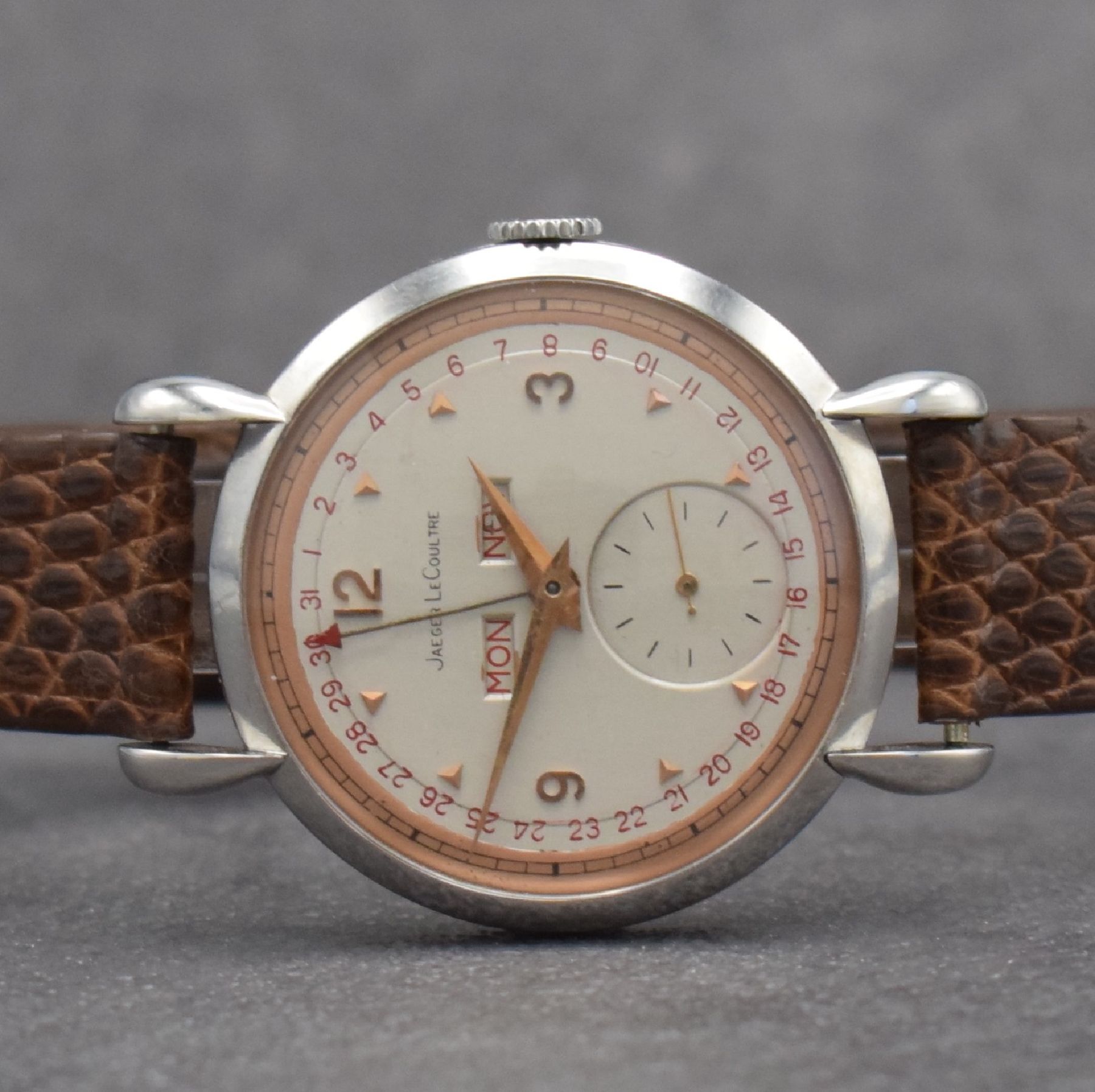 Detail a: Jaeger-LeCoultre Herrenuhr mit Vollkalender in Stahl, Schweiz um 1945, Handaufzug, gedr. Geh. m. Tropfen-förm. Anstößen, silb./rose- farb. ...