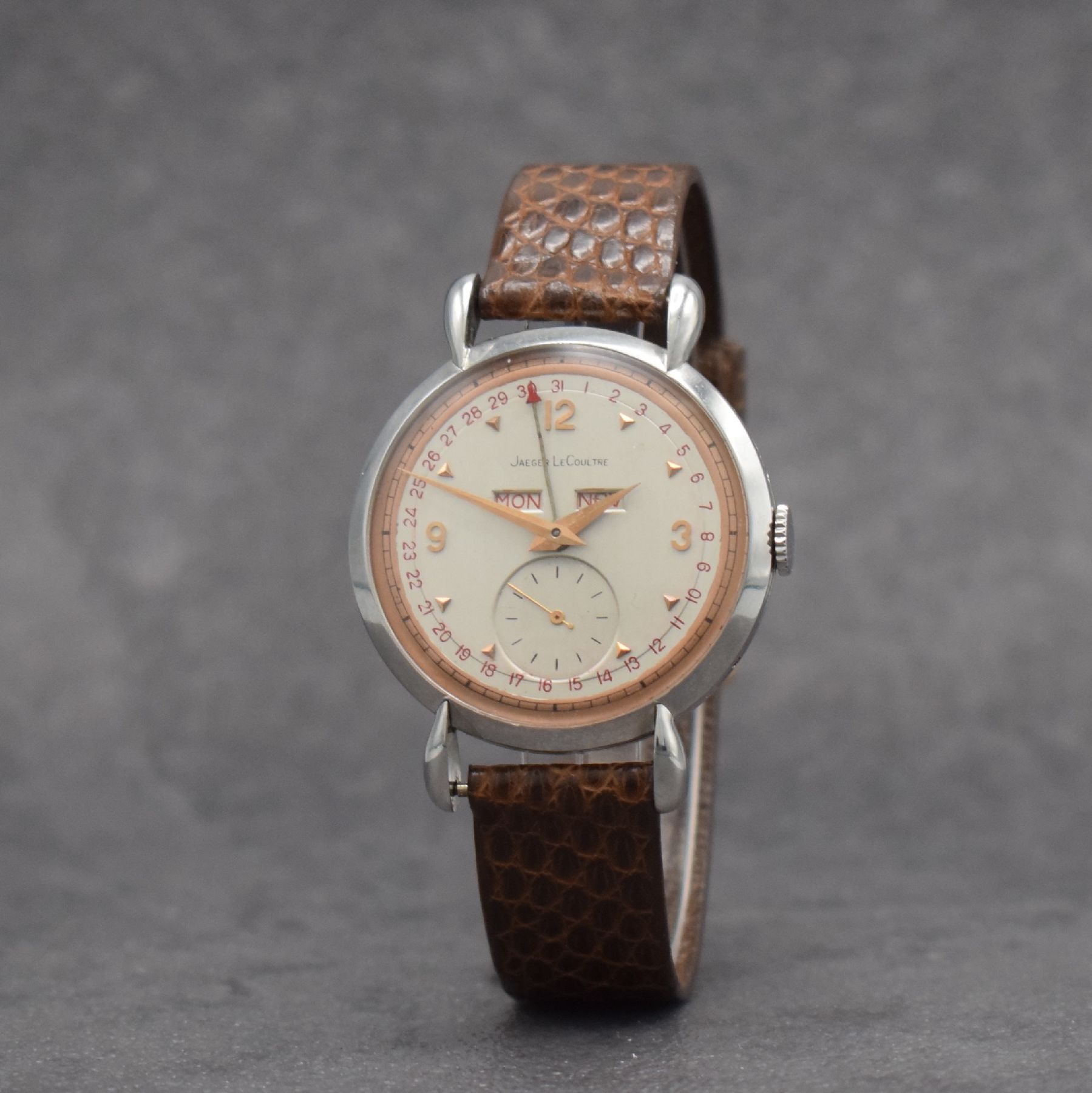 Detail b: Jaeger-LeCoultre Herrenuhr mit Vollkalender in Stahl, Schweiz um 1945, Handaufzug, gedr. Geh. m. Tropfen-förm. Anstößen, silb./rose- farb. ...