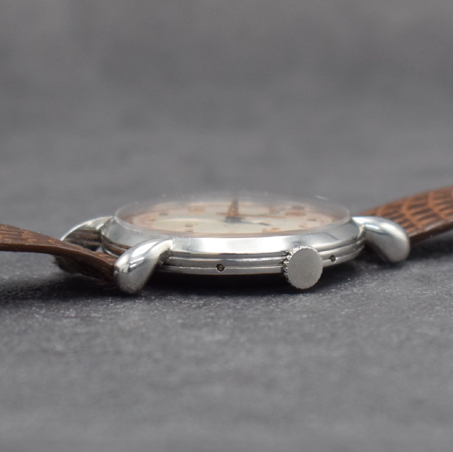 Detail e: Jaeger-LeCoultre Herrenuhr mit Vollkalender in Stahl, Schweiz um 1945, Handaufzug, gedr. Geh. m. Tropfen-förm. Anstößen, silb./rose- farb. ...