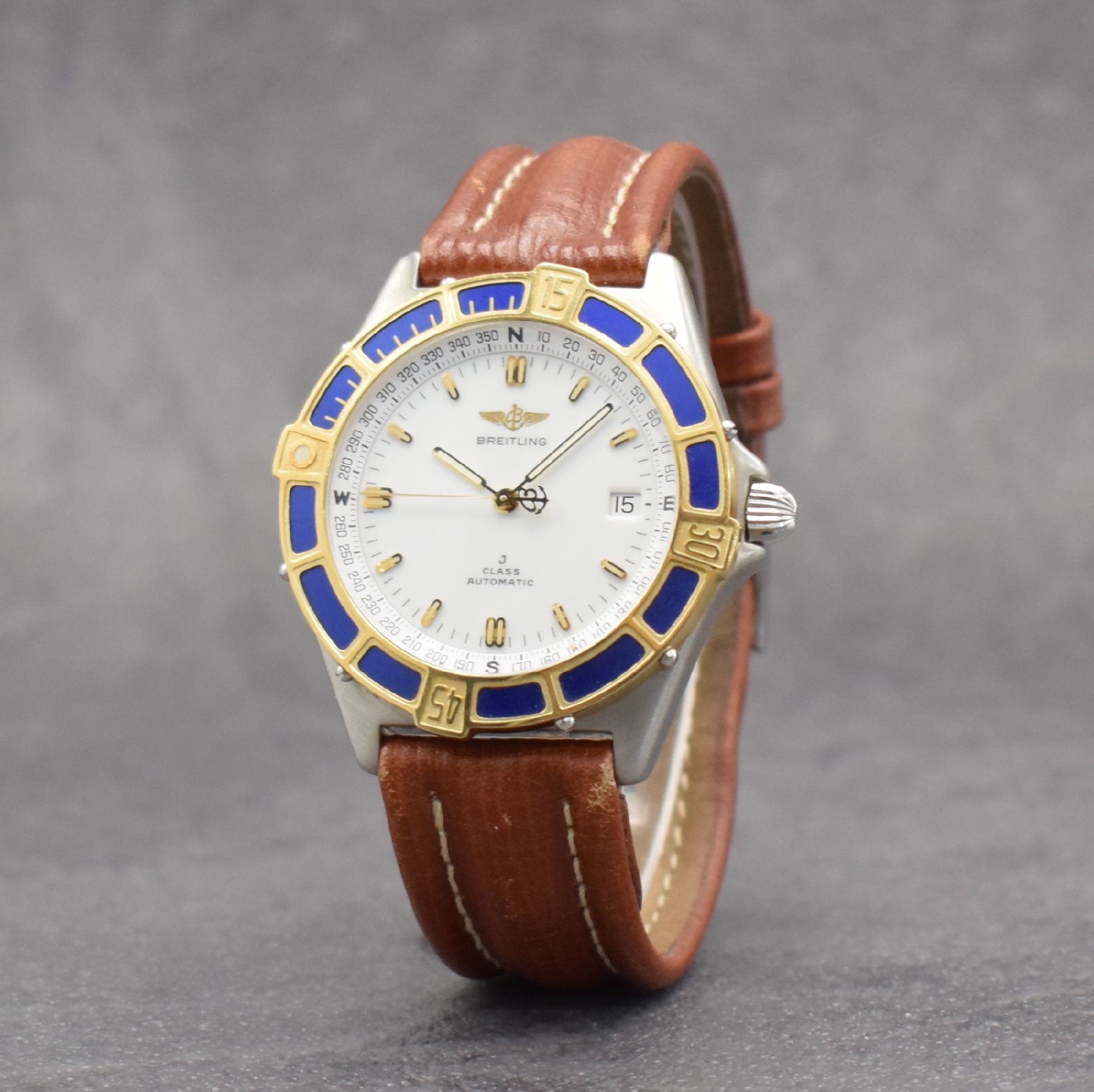 Detail b: BREITLING J-Class Herrenarmbanduhr, Schweiz um 1995, Automatik, Ref. 80250, verschraubtes Edelstahlgeh., eins. drehb. Lünette in GG, orig. Lederband ...
