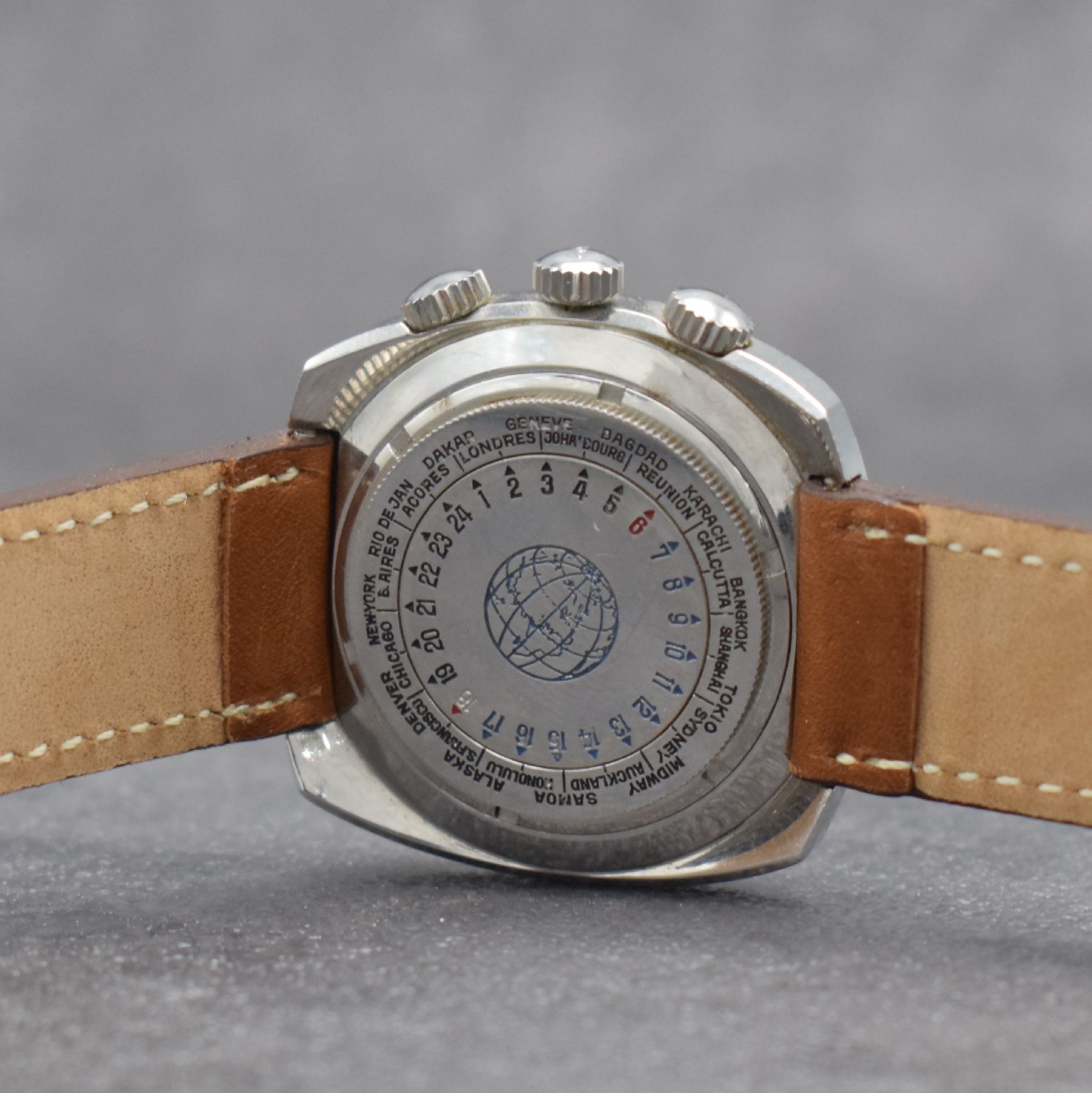 Detail e: MONDIA seltene Herrenarmbanduhr mit Rechenschieber und rückseitiger Weltzeit in Stahl, Schweiz um 1965, Automatik, verschr. Geh., im Boden ...