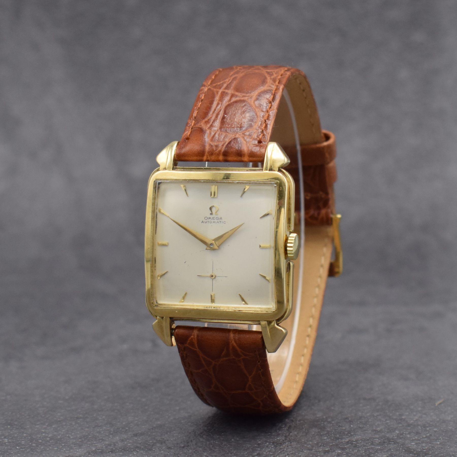 Detail b: OMEGA quadratische Herrenarmbanduhr Referenz 3903 in GG 585/000, Schweiz um 1950, Hammerautomatik, gedr. Boden, tropfenf. Bandanst., silb. Zifferbl., ...