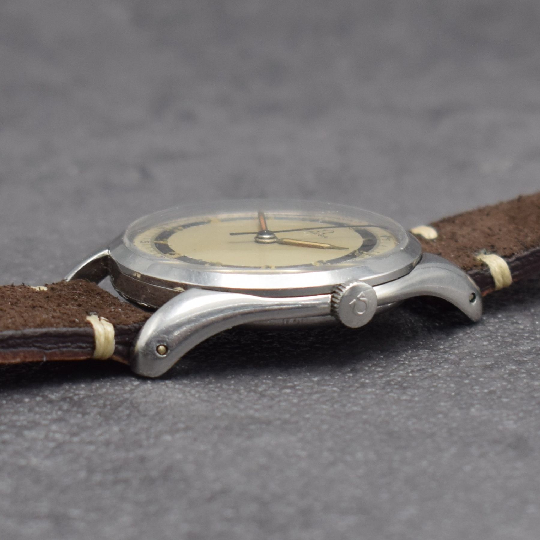 Detail d: OMEGA Herrenarmbanduhr Kal. 30 T2 SC PC in Stahl, Schweiz um 1950, Handaufzug, Ref. 2504-2, Boden & Glasrand aufgedr., silb. 2- farb. Zifferbl. m. ...