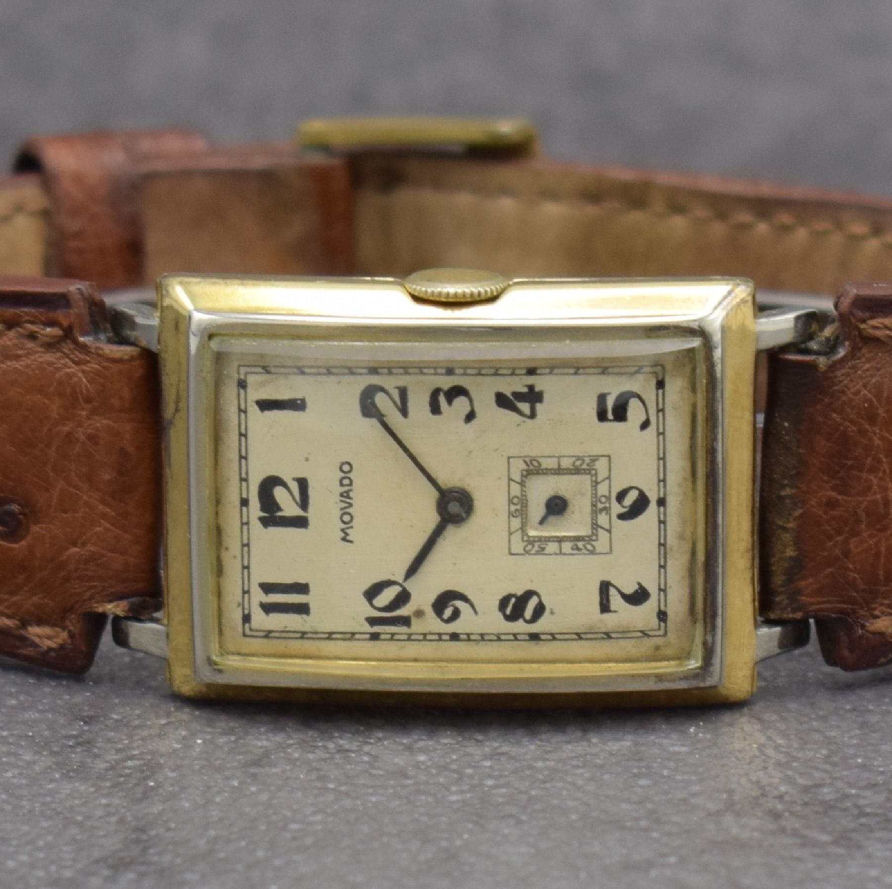 Detail a: MOVADO Herrenarmbanduhr in GG 750/000, Schweiz um 1930, Handaufzug, 2-teil. Scharniergeh., Zifferbl. m. arab. Zahlen rest., schwarze Zeiger, Kal. ...