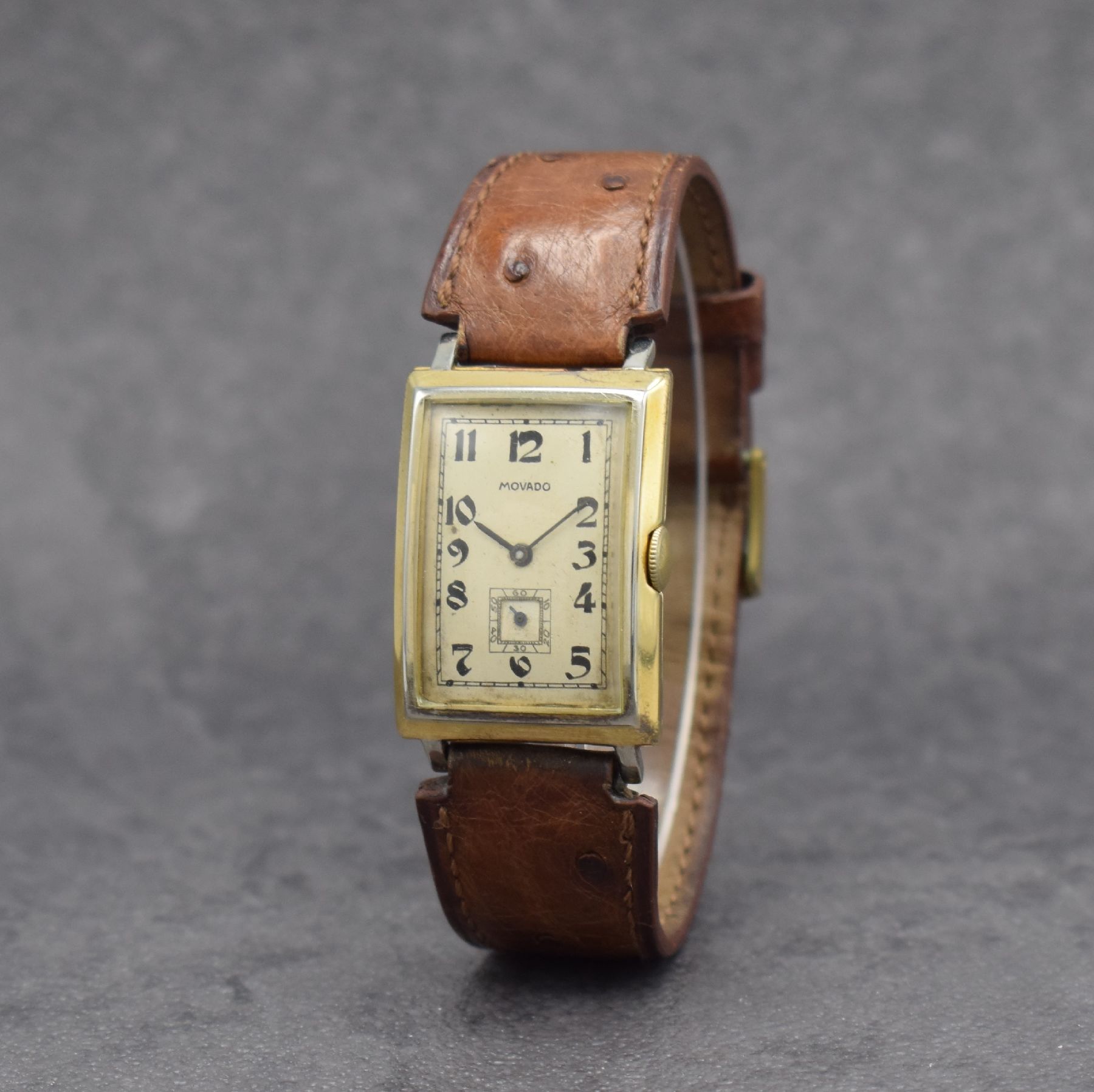 Detail b: MOVADO Herrenarmbanduhr in GG 750/000, Schweiz um 1930, Handaufzug, 2-teil. Scharniergeh., Zifferbl. m. arab. Zahlen rest., schwarze Zeiger, Kal. ...