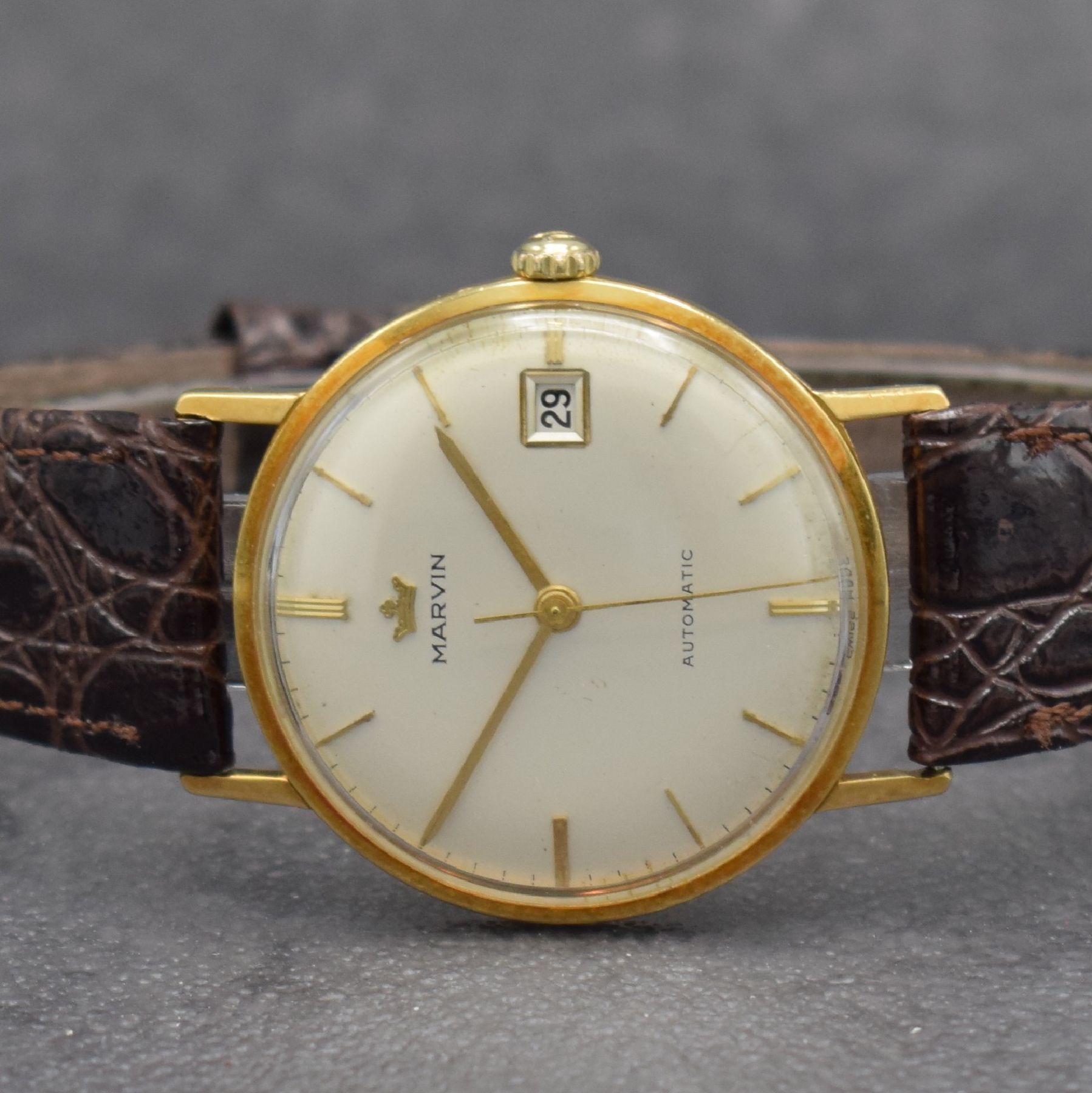Detail a: MARVIN Herrenarmbanduhr in GG 750/000, Schweiz um 1960, Automatik, 3-teil. Geh., Boden & Glasrand aufgedr., silb. Zifferbl. m. aufges. Std.-Ind., ...