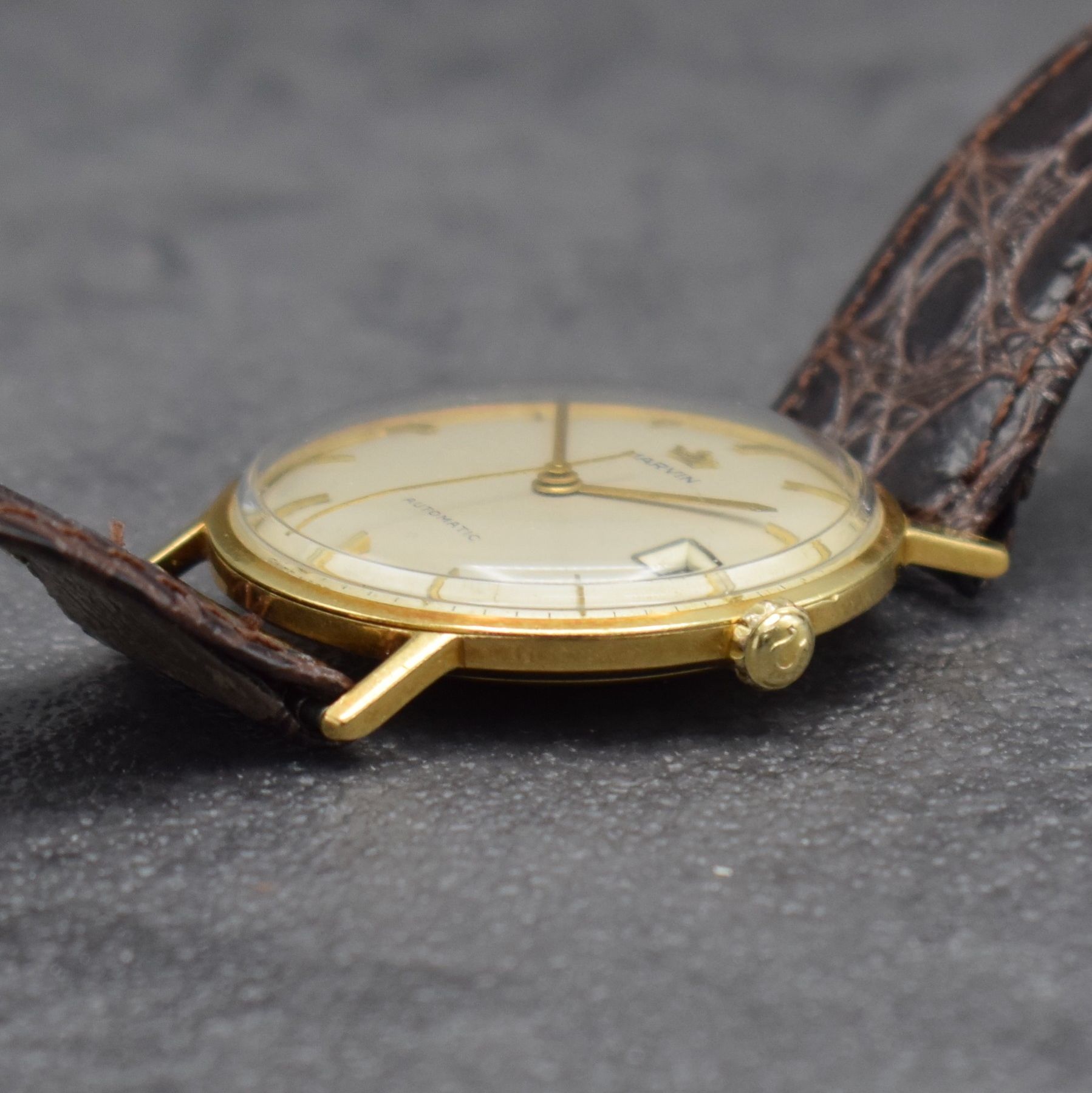 Detail d: MARVIN Herrenarmbanduhr in GG 750/000, Schweiz um 1960, Automatik, 3-teil. Geh., Boden & Glasrand aufgedr., silb. Zifferbl. m. aufges. Std.-Ind., ...
