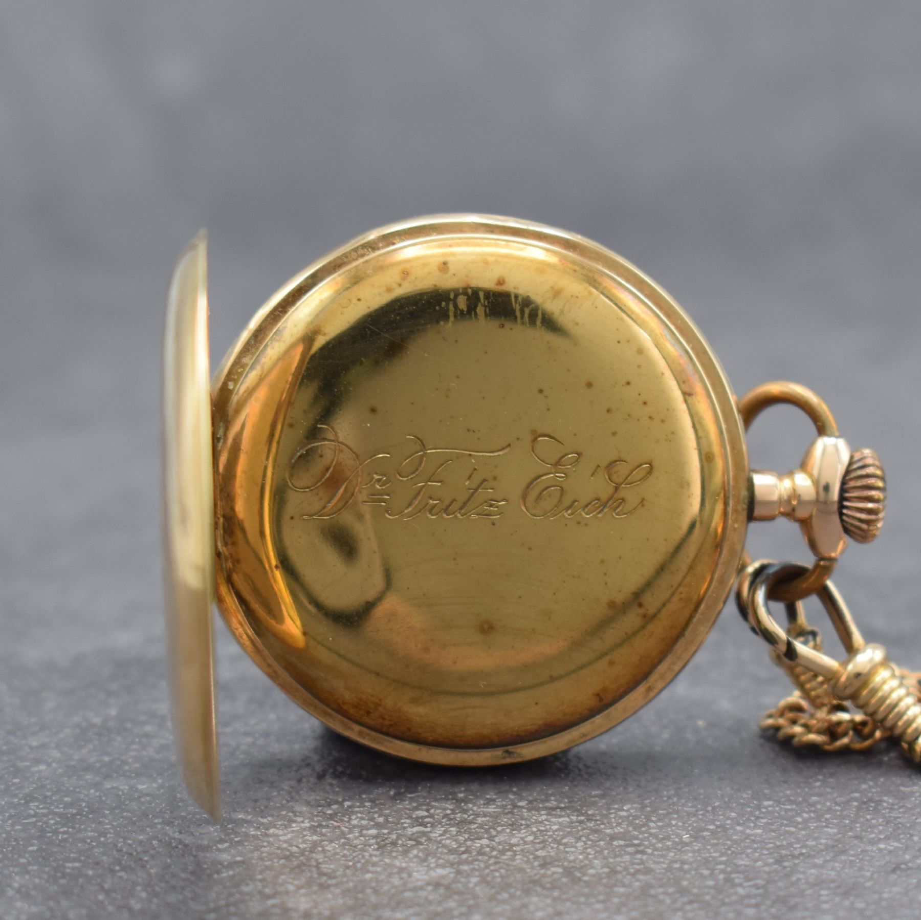 Detail c: Offene Taschenuhr in RG 585/000, Schweiz um 1900, guill. Rückdeckel mit Monogramm, Metallcuvette m. Widmung, Emailzifferbl. m. arab. Zahlen, gold. ...