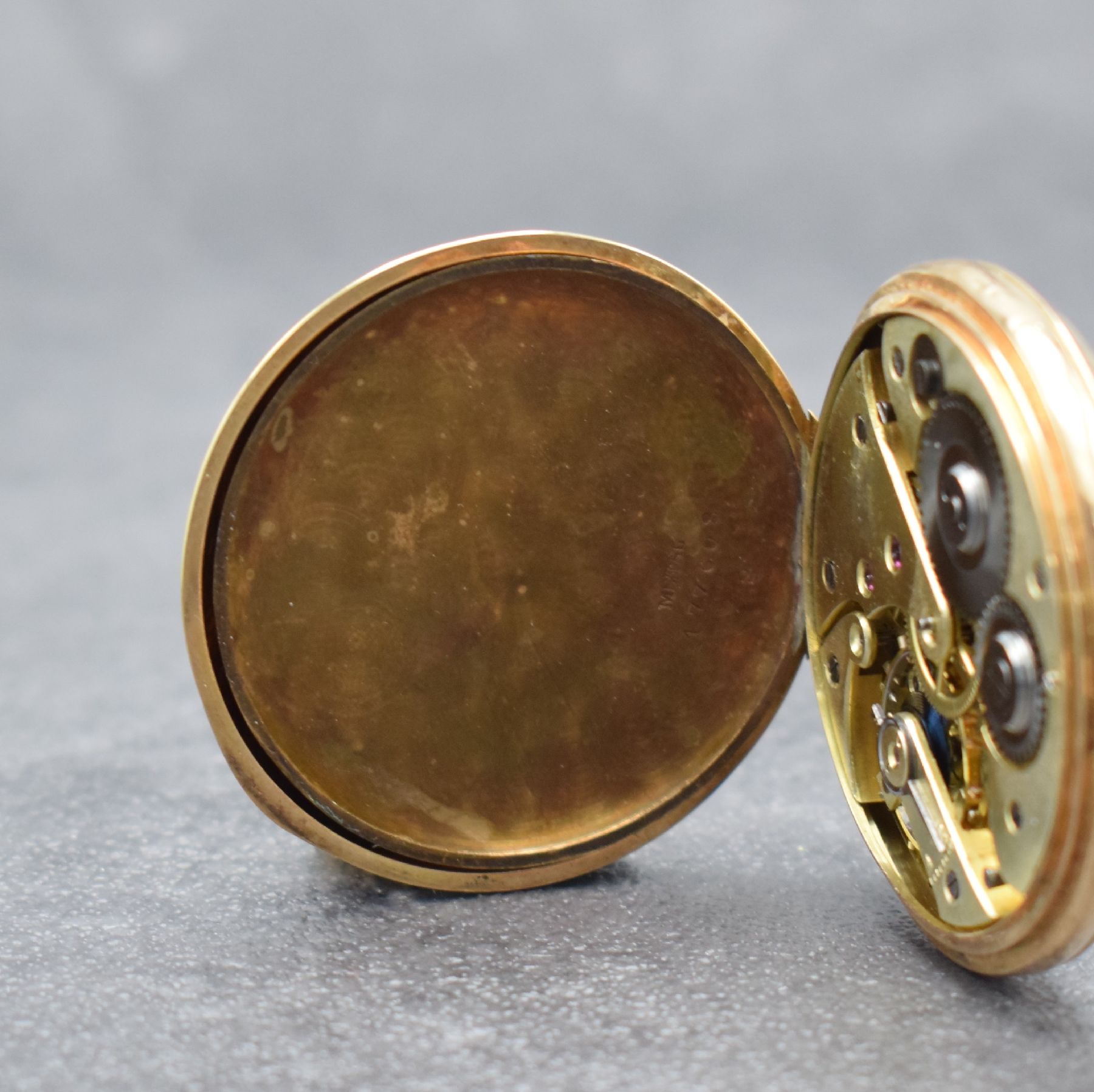 Detail d: Offene Taschenuhr in RG 585/000, Schweiz um 1900, guill. Rückdeckel mit Monogramm, Metallcuvette m. Widmung, Emailzifferbl. m. arab. Zahlen, gold. ...