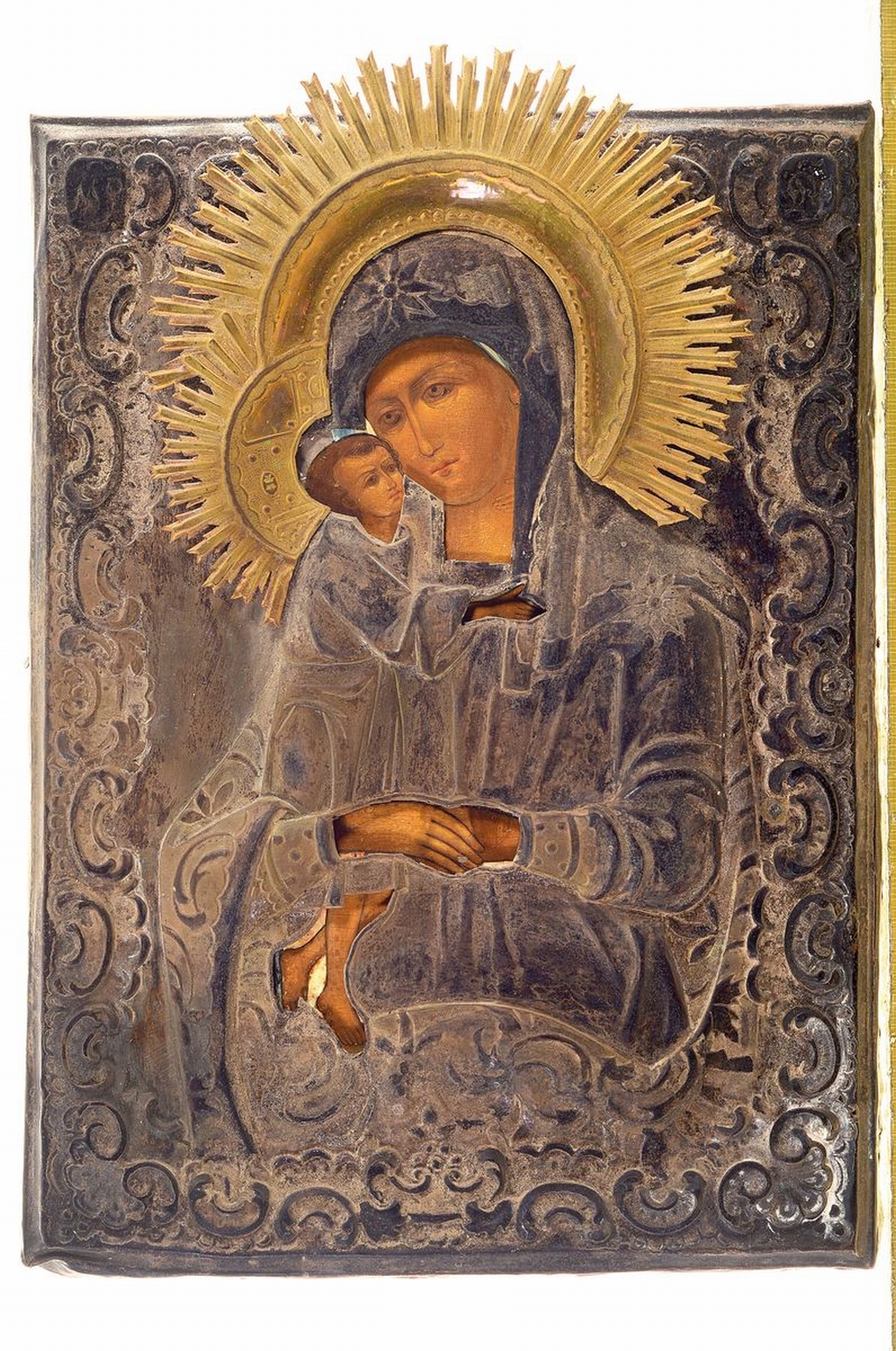 Detail k: Ikone, Russland, um 1900, Gottesmutter mit Kind, Tempera auf Holz, reich geprägtes versilbertes Metalloklad mit vergoldeten Heiligenscheinen, unter ...