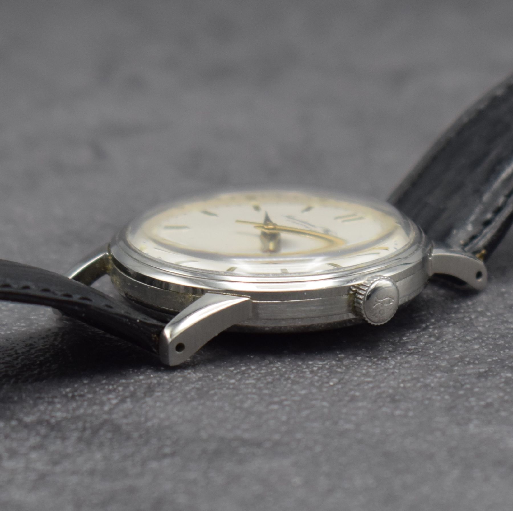 Detail d: IWC Herrenarmbanduhr mit Kaliber 852 in Stahl, Schweiz um 1953, Automatik, 3-teil. Geh., Boden & Glasrand aufgedr., silb. Zifferbl. m. gold. ...