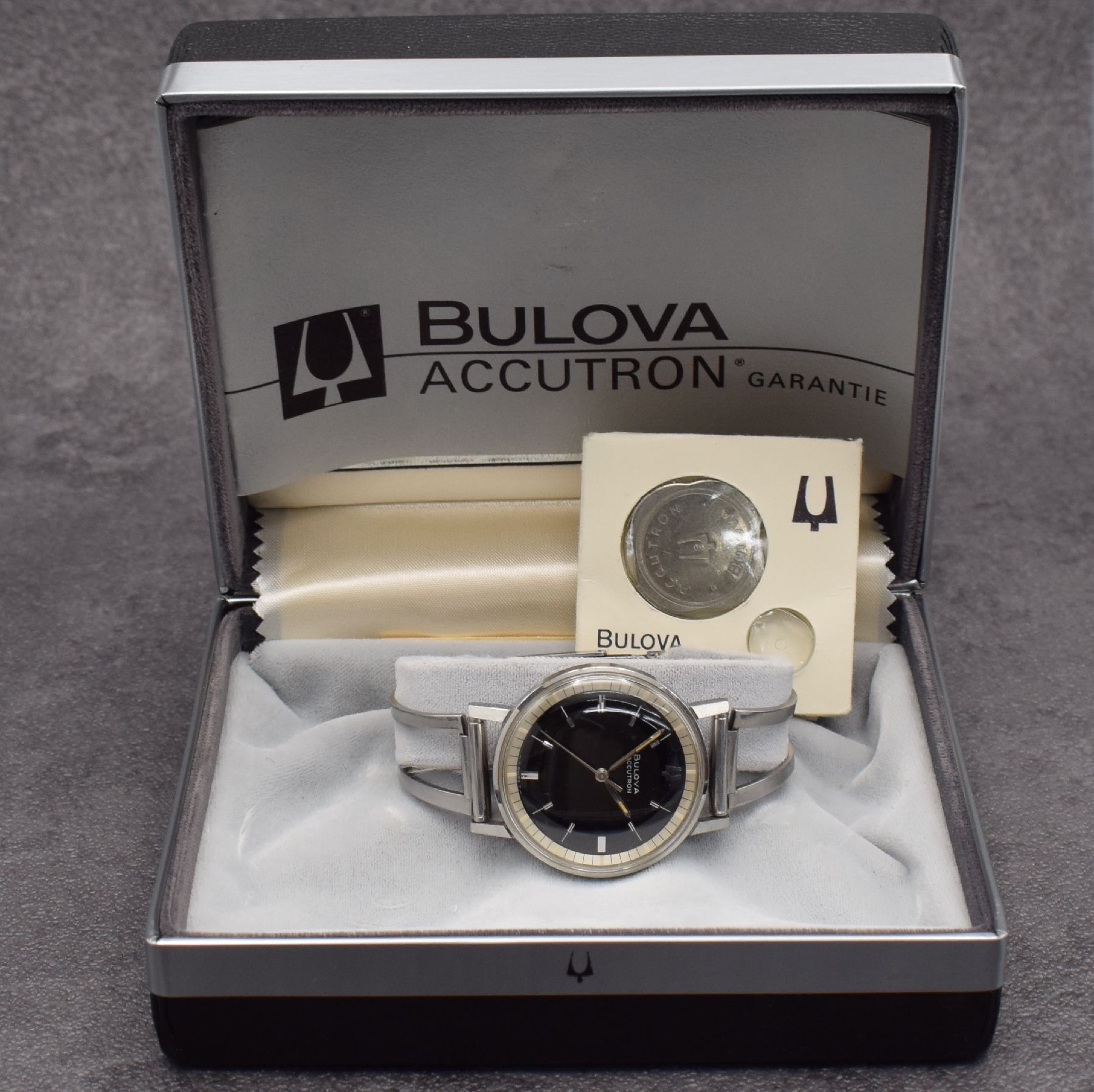 Detail d: BULOVA Accutron Herrenarmbanduhr in Edelstahl, verschr. Boden, neutr. Spangen- Gliederband, Batteriefach & Zeigerstellung im Geh.-Boden, schwarzes ...