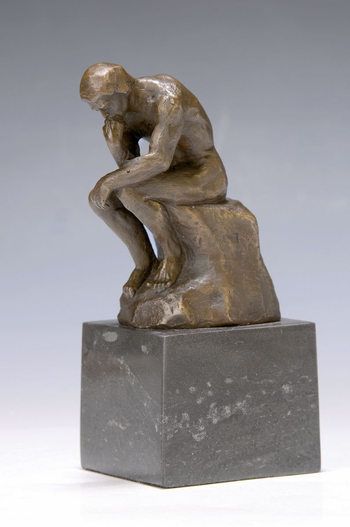 Bronzeskulptur nach Auguste Rodin, "Der Denker", rückseitig signiert, auf grauem Marmorsockel, H. ca. 13/20 cm