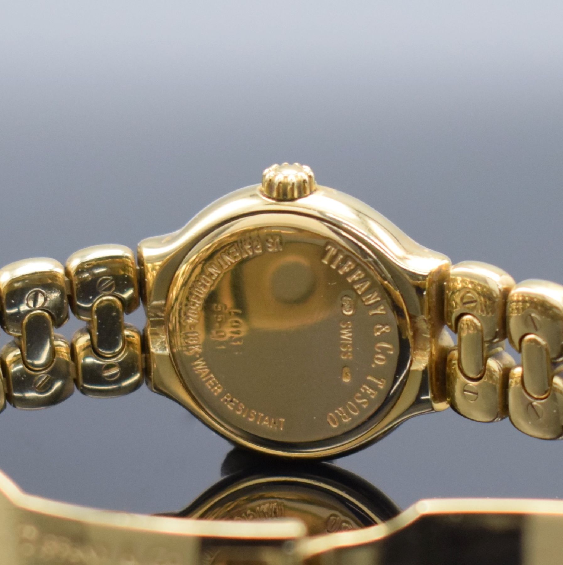 Detail e: TIFFANY Tesoro Damenarmbanduhr in GG 750/000, Schweiz um 2013, quarz, Boden aufgedr., integr. Band m. Faltschl., weißes Zifferbl., gold. Indizes & ...