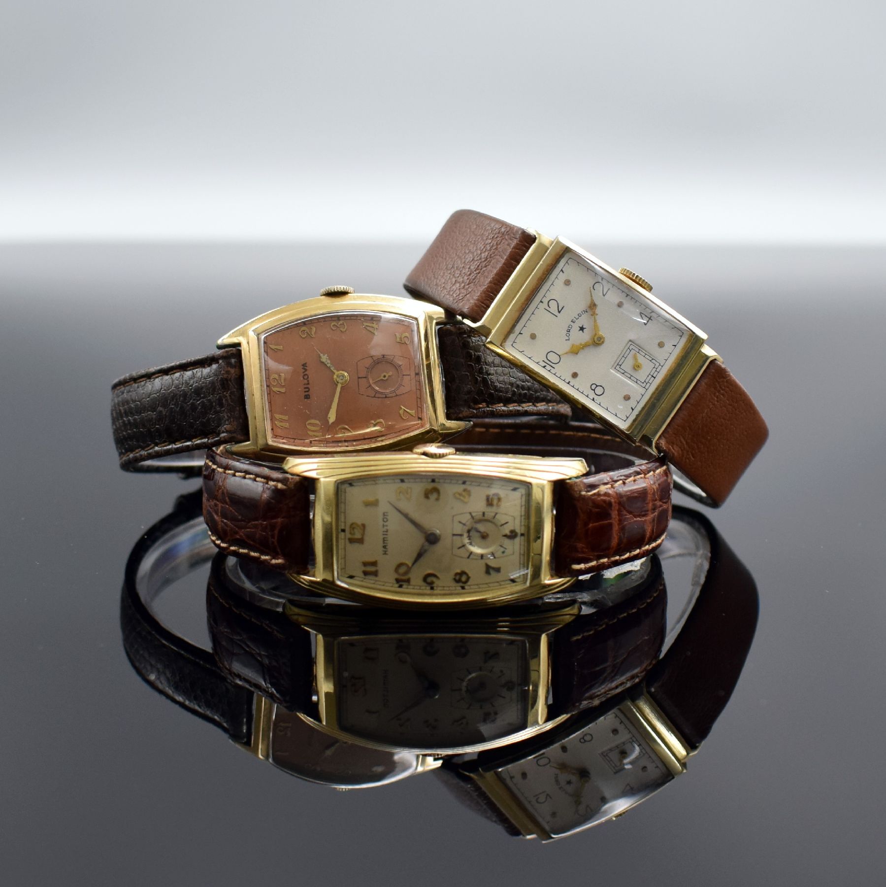 LORD ELGIN, BULOVA, HAMILTON 3 Armbanduhren, USA um 1940, Handaufzug, 1.) Lord Elgin in GG 585/000, Kal. 559, M. ca. 27 x 20 mm, Überh. fäll., EZ ...