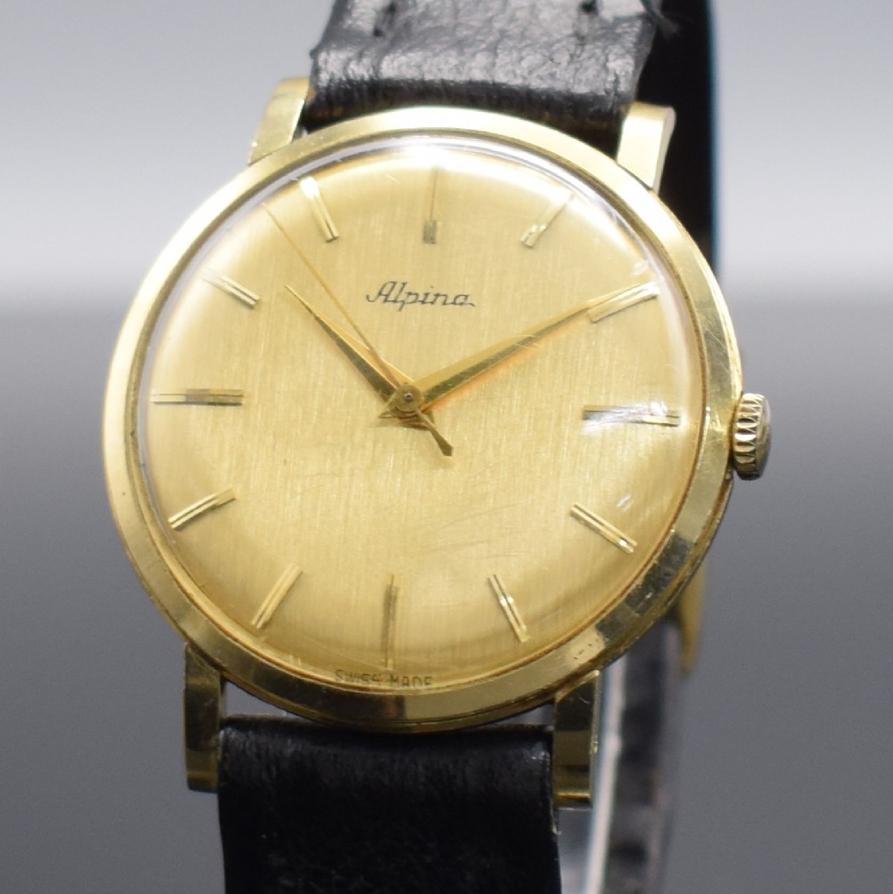 Detail c: ALPINA Herrenarmbanduhr in GG 585/000, Schweiz um 1960, Handaufzug, 3-teil. Gehäuse, Boden & Glasrand aufgedr., gold. Zifferbl. m. aufges. ...
