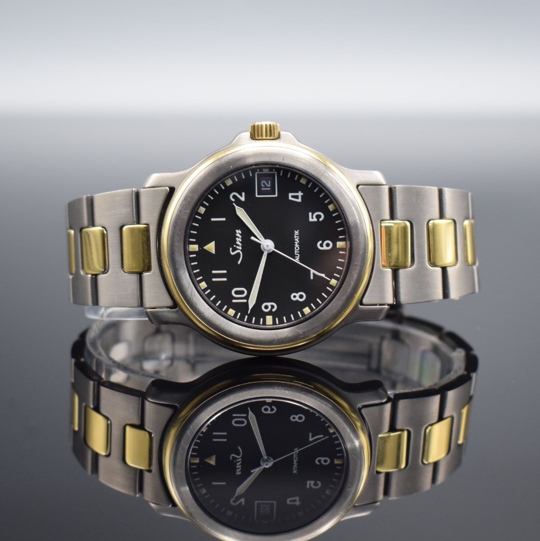 SINN Chronometer Herrenarmbanduhr, Schweiz/ Deutschland um 1995, Automatik, Titan/Gold komb., Gliederband m. Faltschl., schwarzes Zifferbl. m. arab. ...